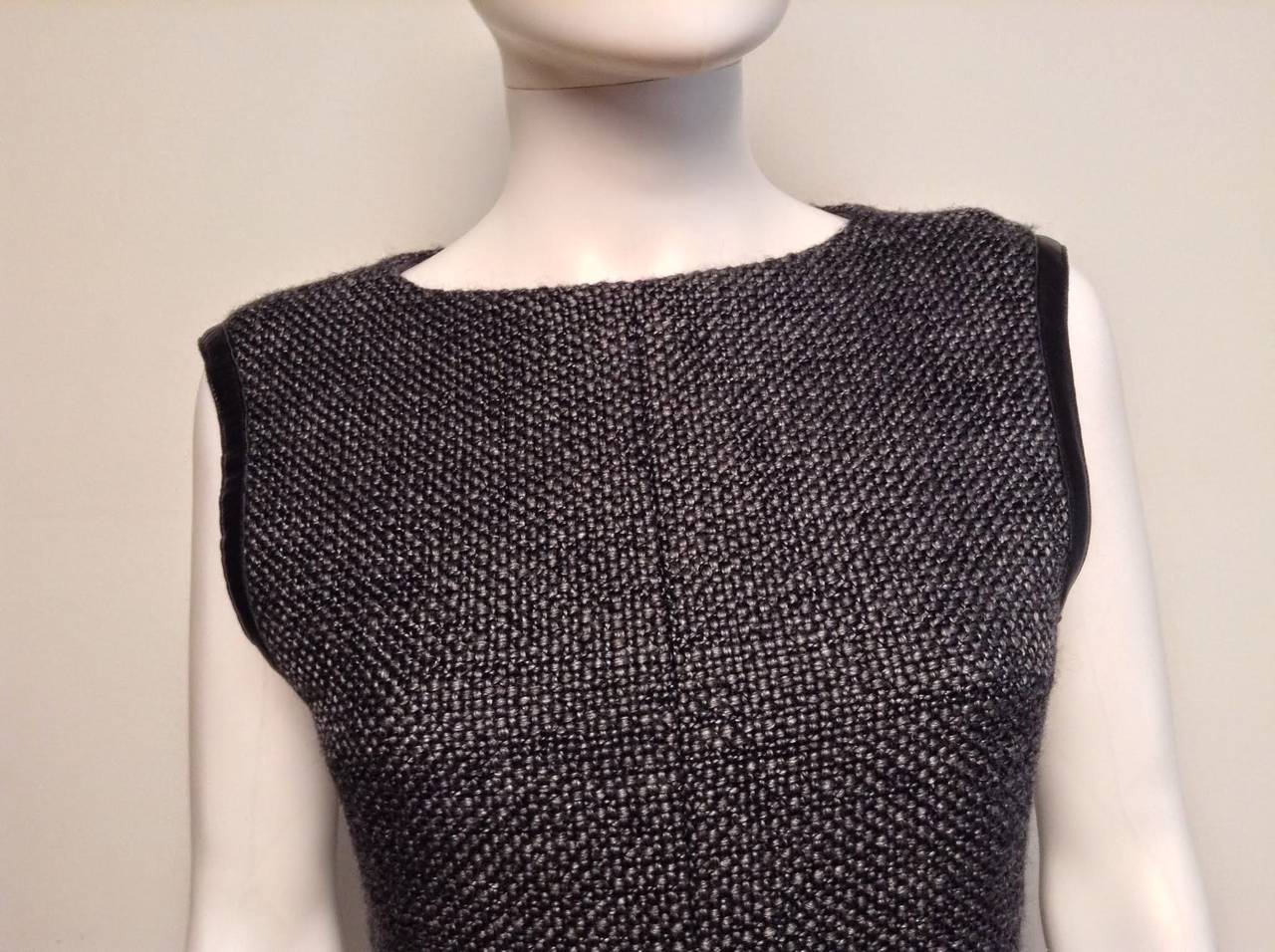Classic and beautifully tailored Chanel grey wool vest and skirt suit. 

Skirt hem is trimmed in leather, invisible zip closure. 

Vest top has 7 gunmetal grey Chanel branded buttons at the back, arm holes are trimmed in leather, 

From