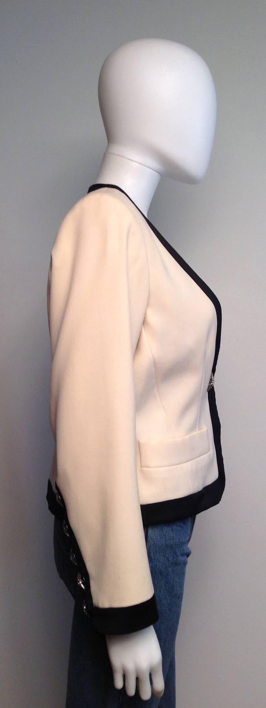 Cream crop blazer trimmed in black with star detail buttons on sleeve and closure.

Measurements: bust 40