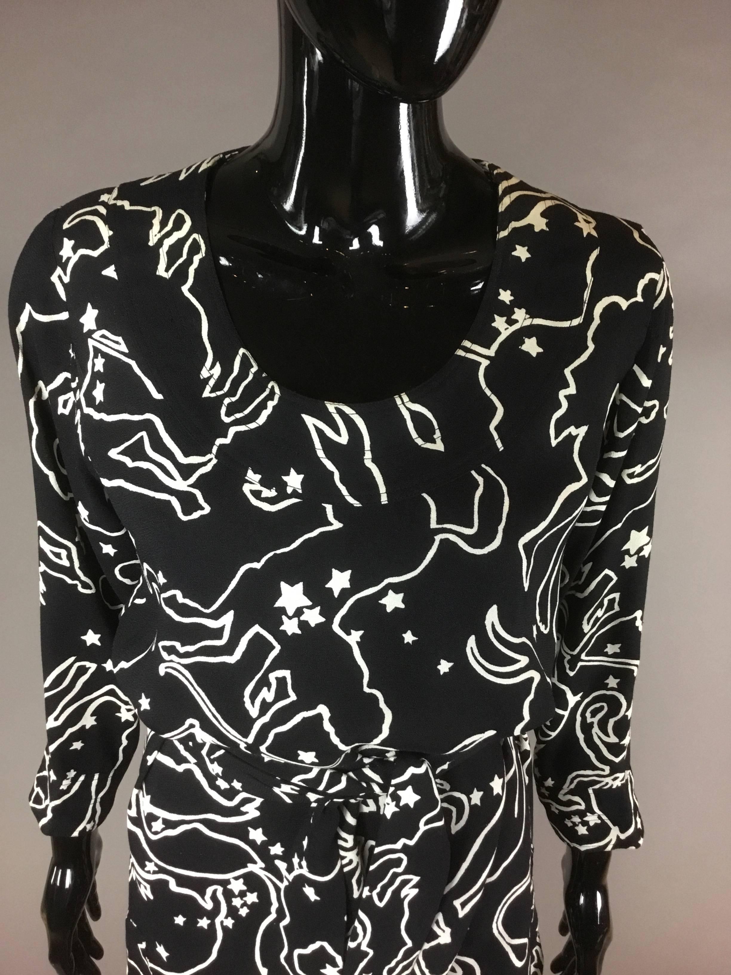 An iconic zodiac print dress by YSL from the eighties.
This is a long sleeve simple shape tunic with four inch slits at either side, and a long self belt. 
