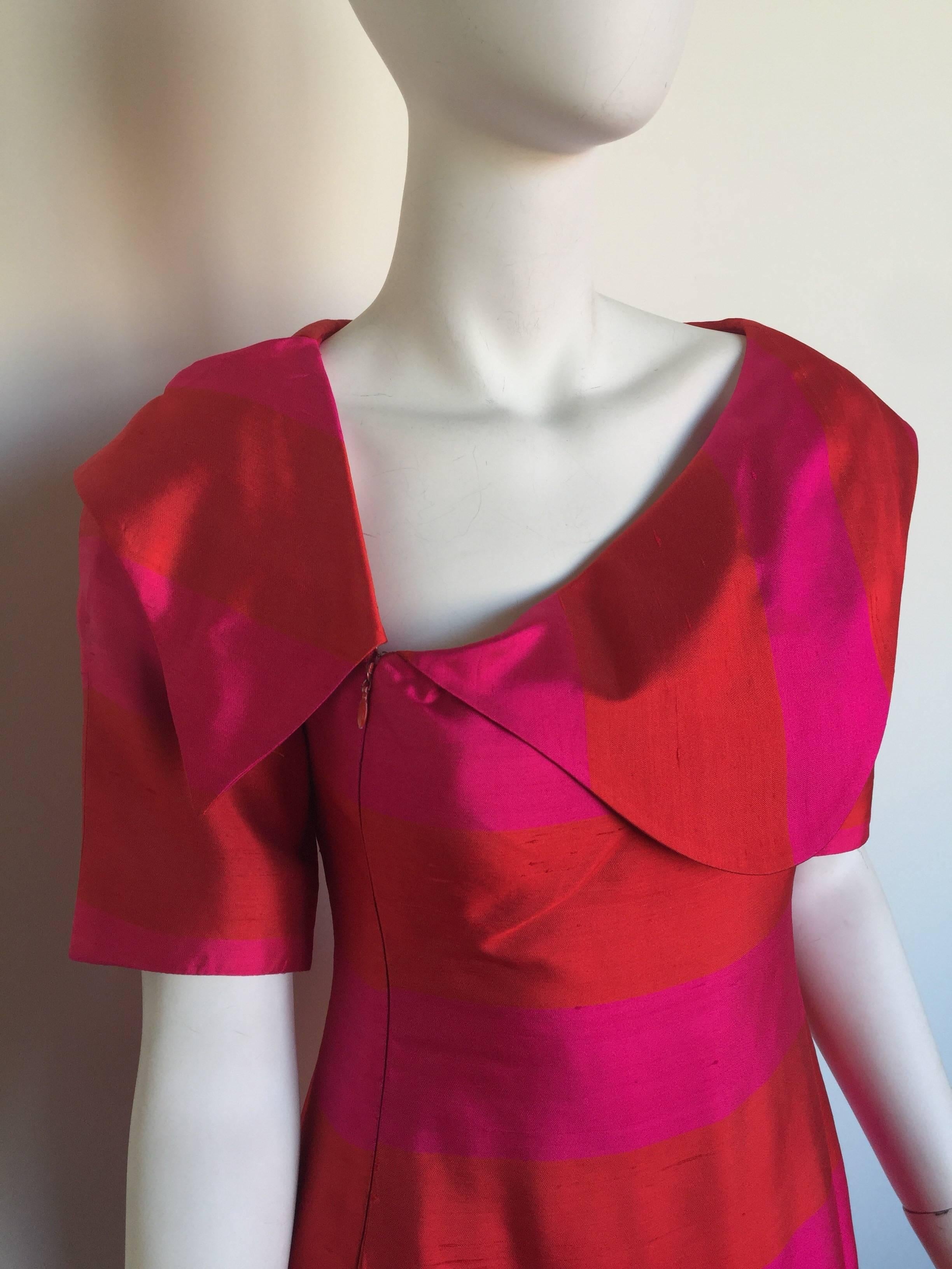 This Lanvin dress is from the 1960s.  This short sleeved dress has bright red and pink horizontal stripes. It has an asymmetrical peter pan collar and a front hidden zipper enclosure. There is a single front pocket. 

BUST: 32"
WAIST: