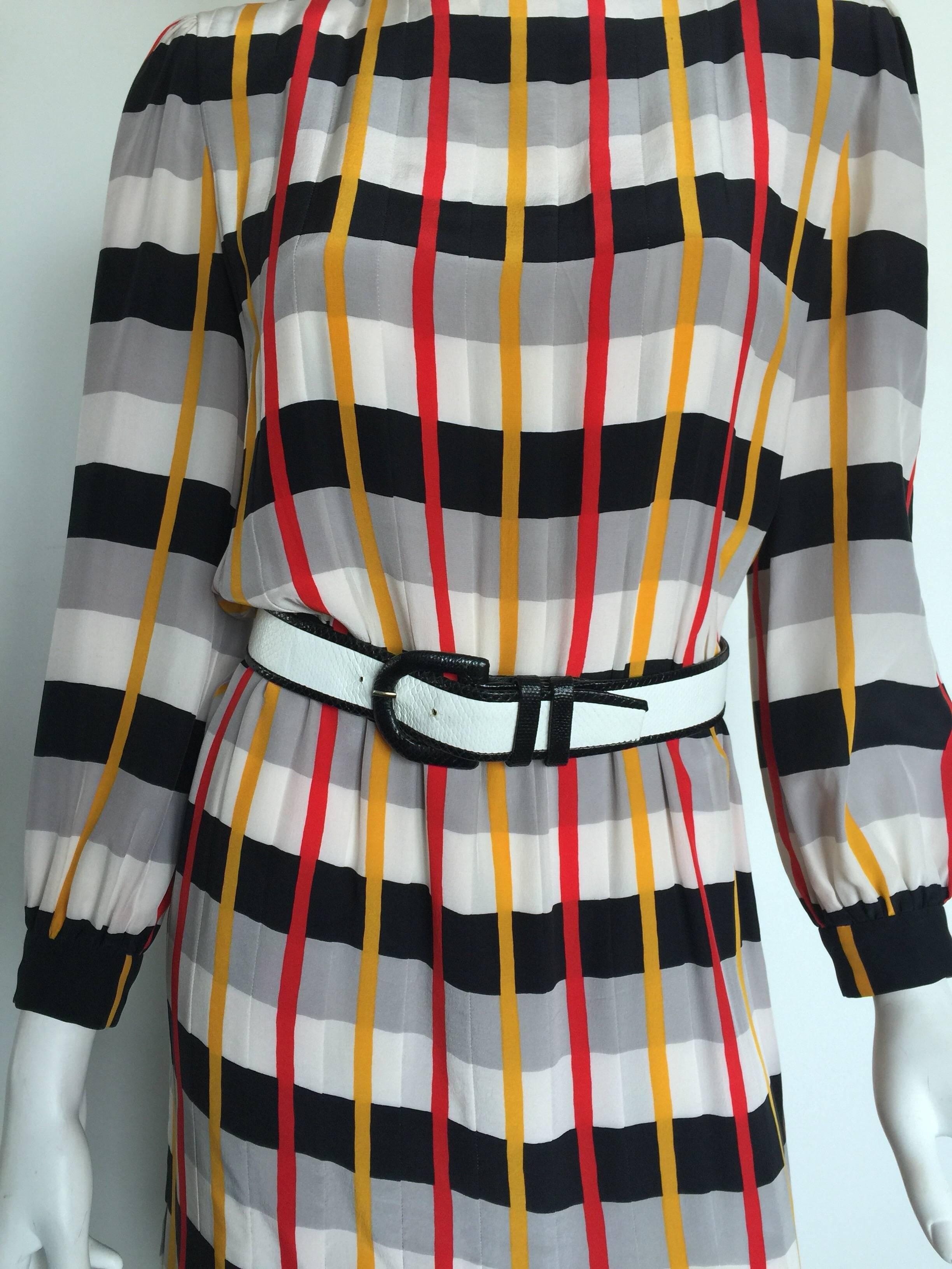 This Bill Blass plaid dress is from 1970s. This long sleeved dress has grey and black horizontal stripes along with red and yellow vertical stripes which create a unique plaid print. It is reminiscent of Marc Jacobs Spring/Summer 2013 collection.