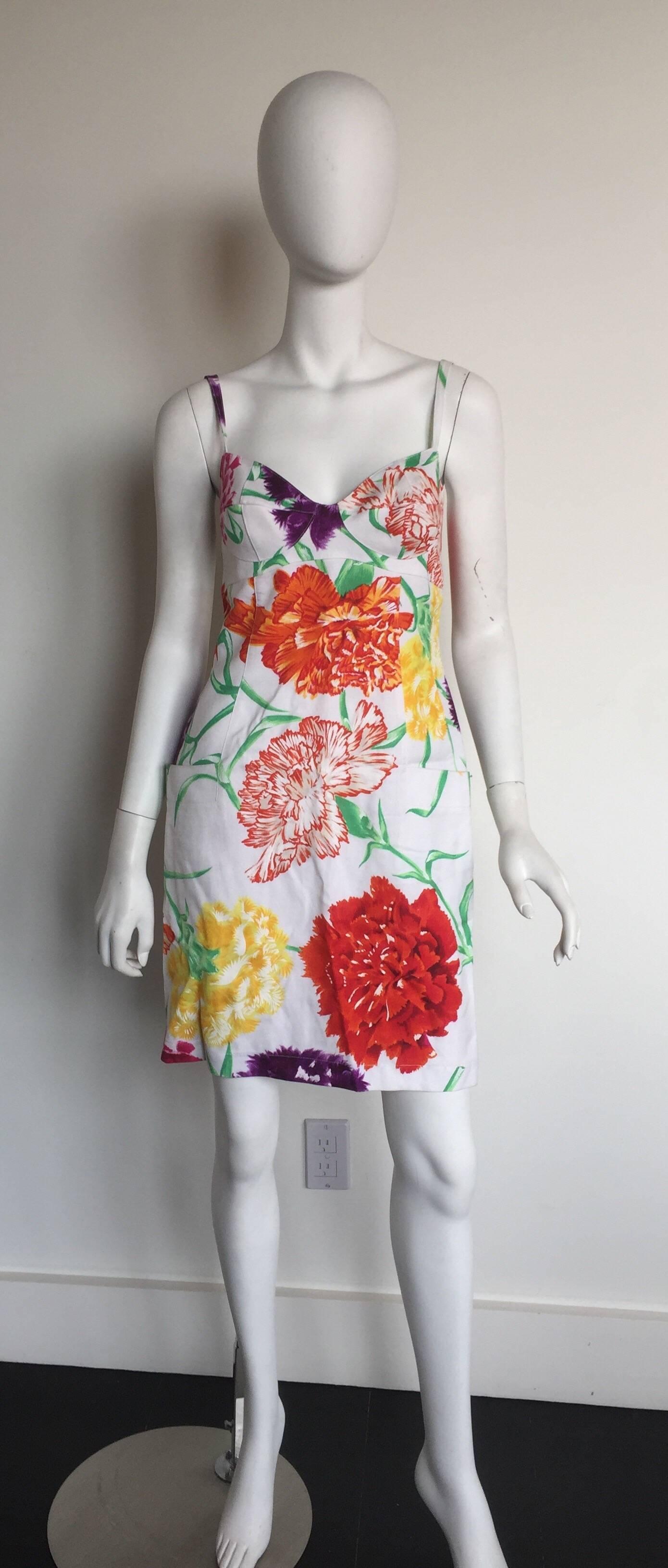 This linen dress is from the 1980s.  Spaghetti strapped sweat heart neckline floral dress is a great summer dress. Color pallet of bright oranges and white creates the mood for summer. With a short length and blended in patch pockets is what makes