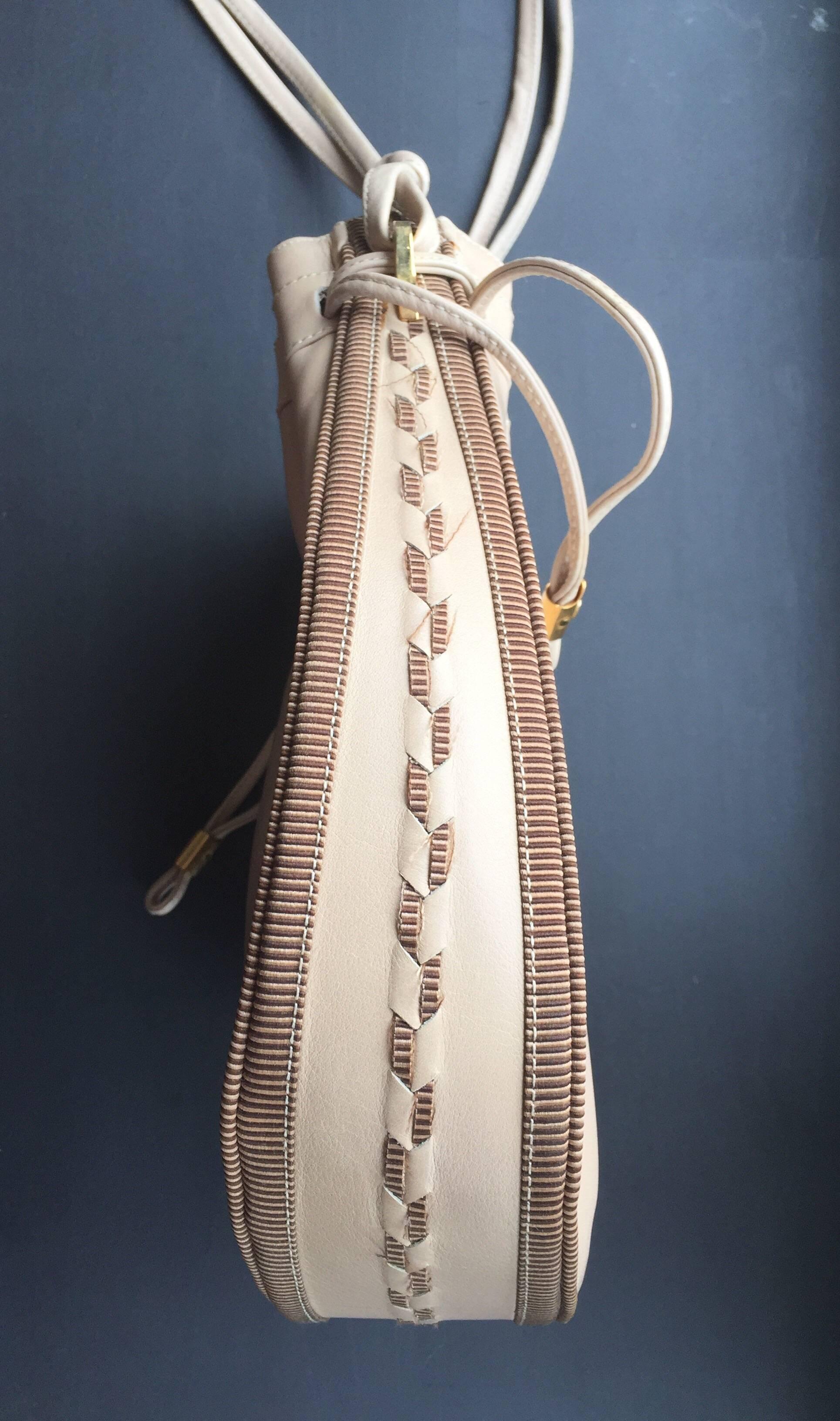 This nude leather Gucci Bucket bag has a drawstring closure and a shoulder or cross body strap.