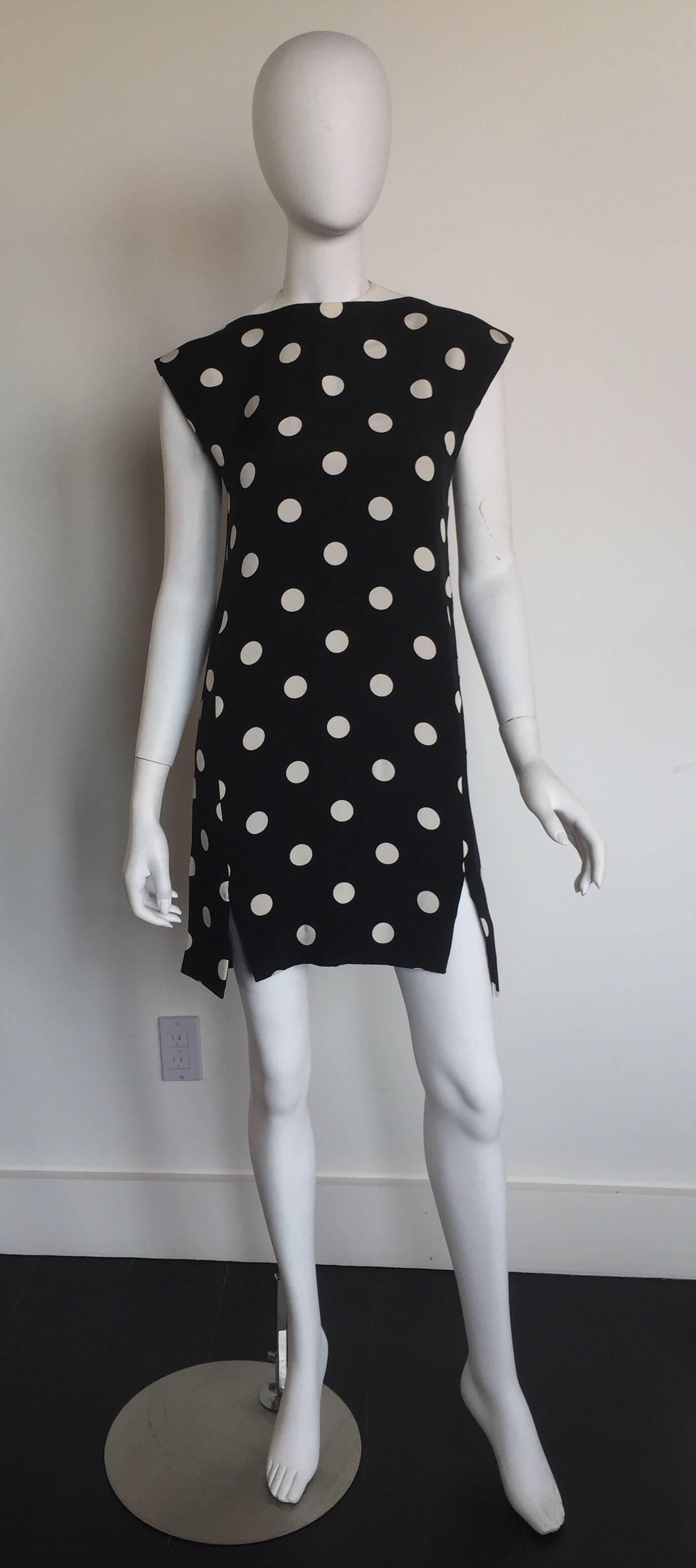 This dress is from the late 1970's.  This black silk dress has white polka dots and a white ribbed collar. There are two small slits in the front of the dress above each knee.

BUST: 36