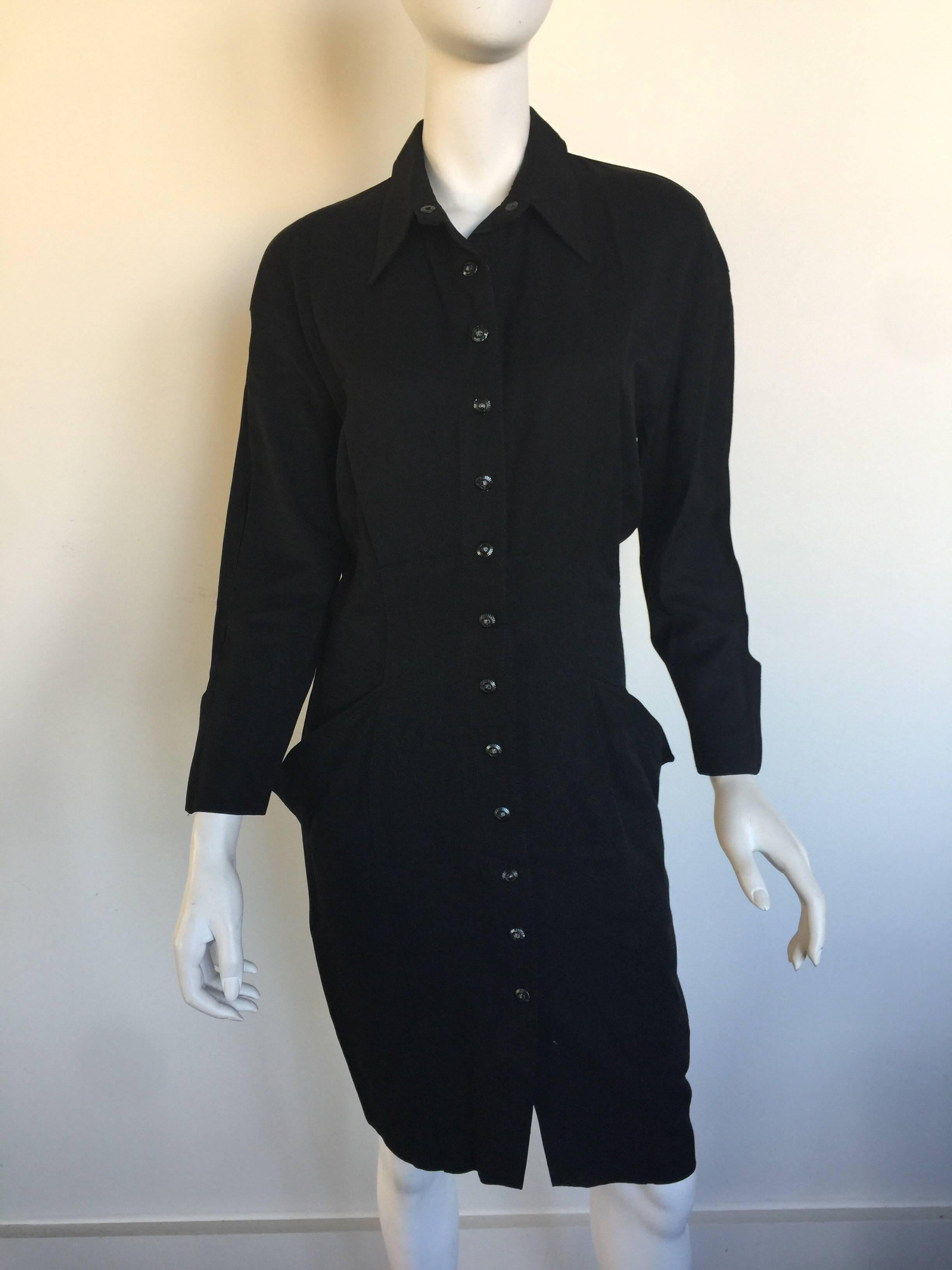 This black tailored Thierry Mugler dress is from the early 90s. This tailored shirt dress is wool gabardine and has front snap closures, from the neck to 8