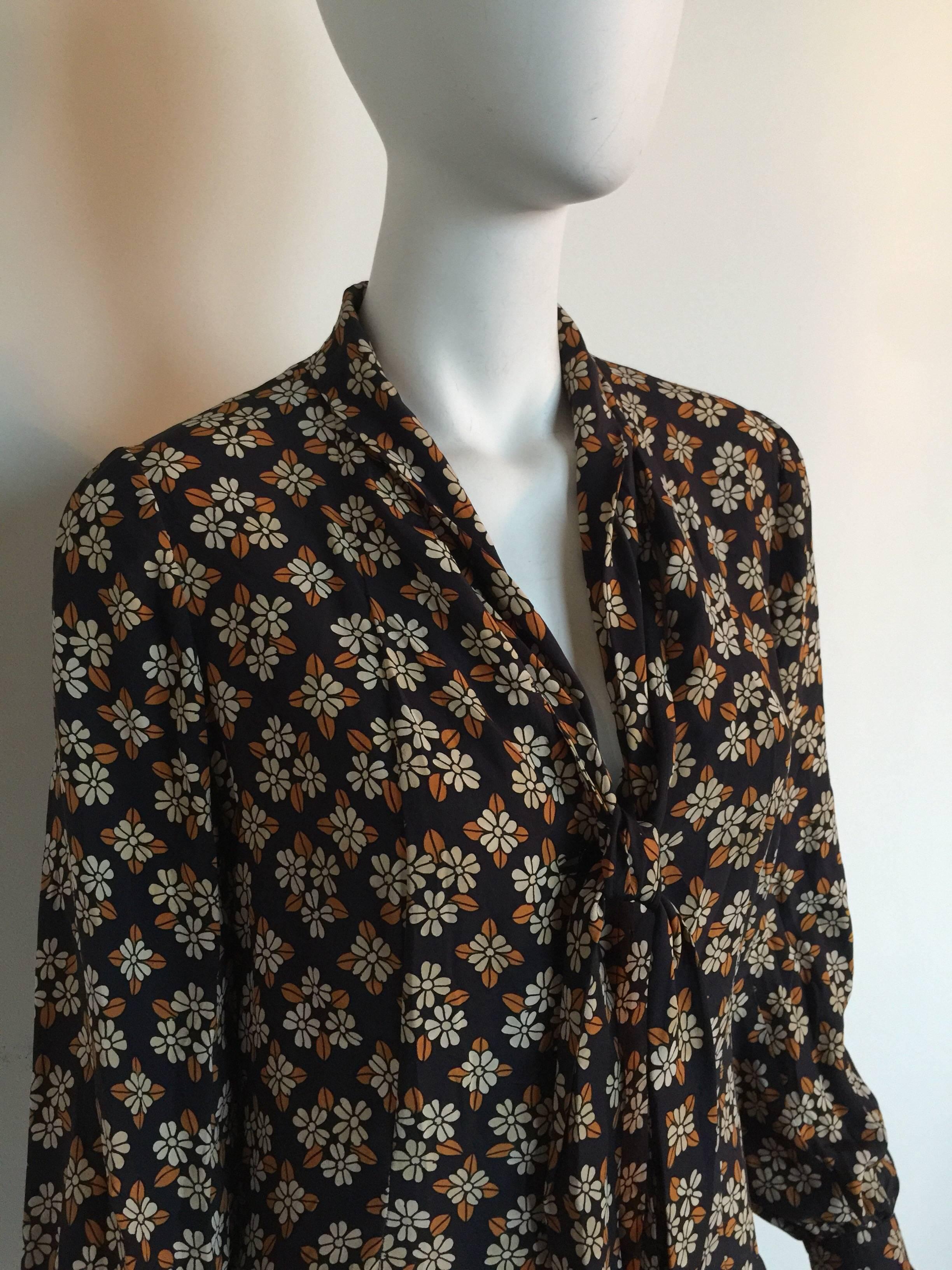 This 1970s Emanuel Ungaro Parallele dress is silk print with a drop waist and a pleated skirt.  The top half is button down the middle.  