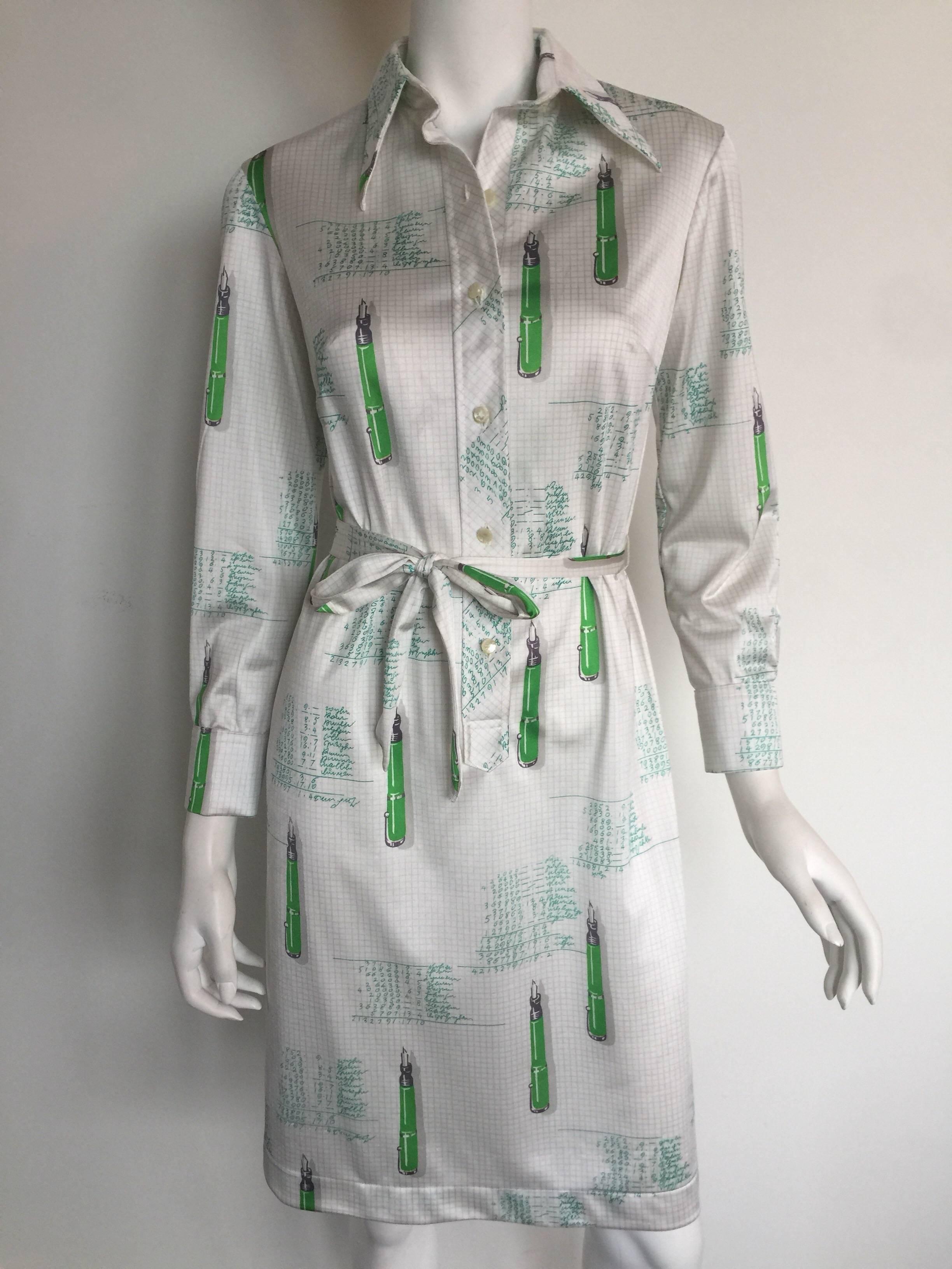 This Lanvin shirtdress is from the 1970s.  The dress has a faint grey and white school notebook grid print with green pens and math scribble.  It is an adorable and unique print.  The neck has an exaggerated V collar lapel as is very 70s.  There is