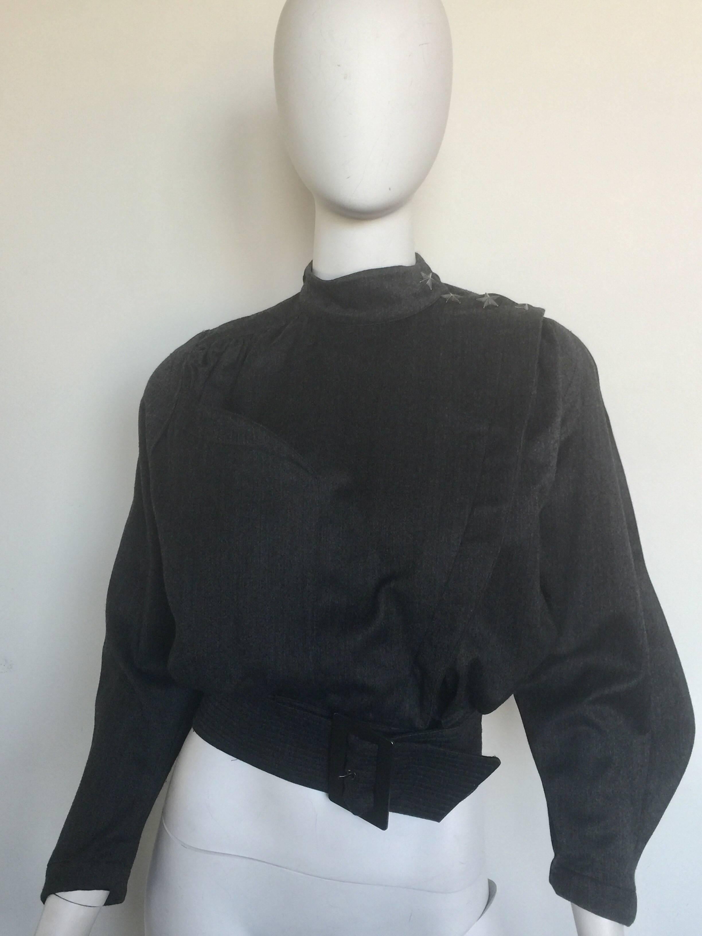 This 1980s cropped Thierry bugler jacket is a charcoal grey.  it has silver star buttons on the right shoulder and a signature bugler waist belt.  It looks great closed or worn open.