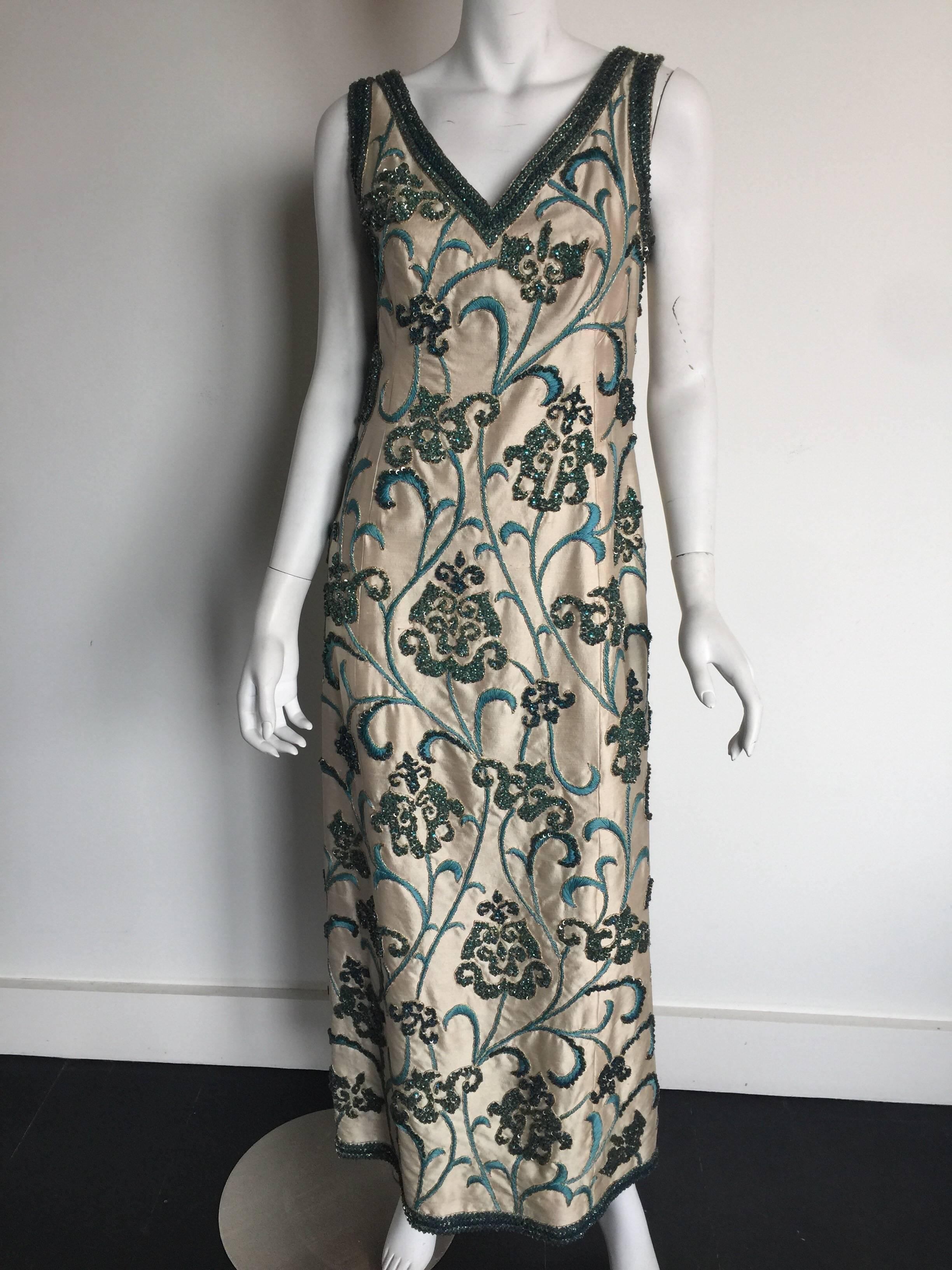 This 1960s sleeveless beaded gown is in good condition for its age.  The floral blue and turquoise beading is beautiful and it fits roughly a 2-4 but please check measurements for exact sizing as it was a custom pieces.  This is from the archive of