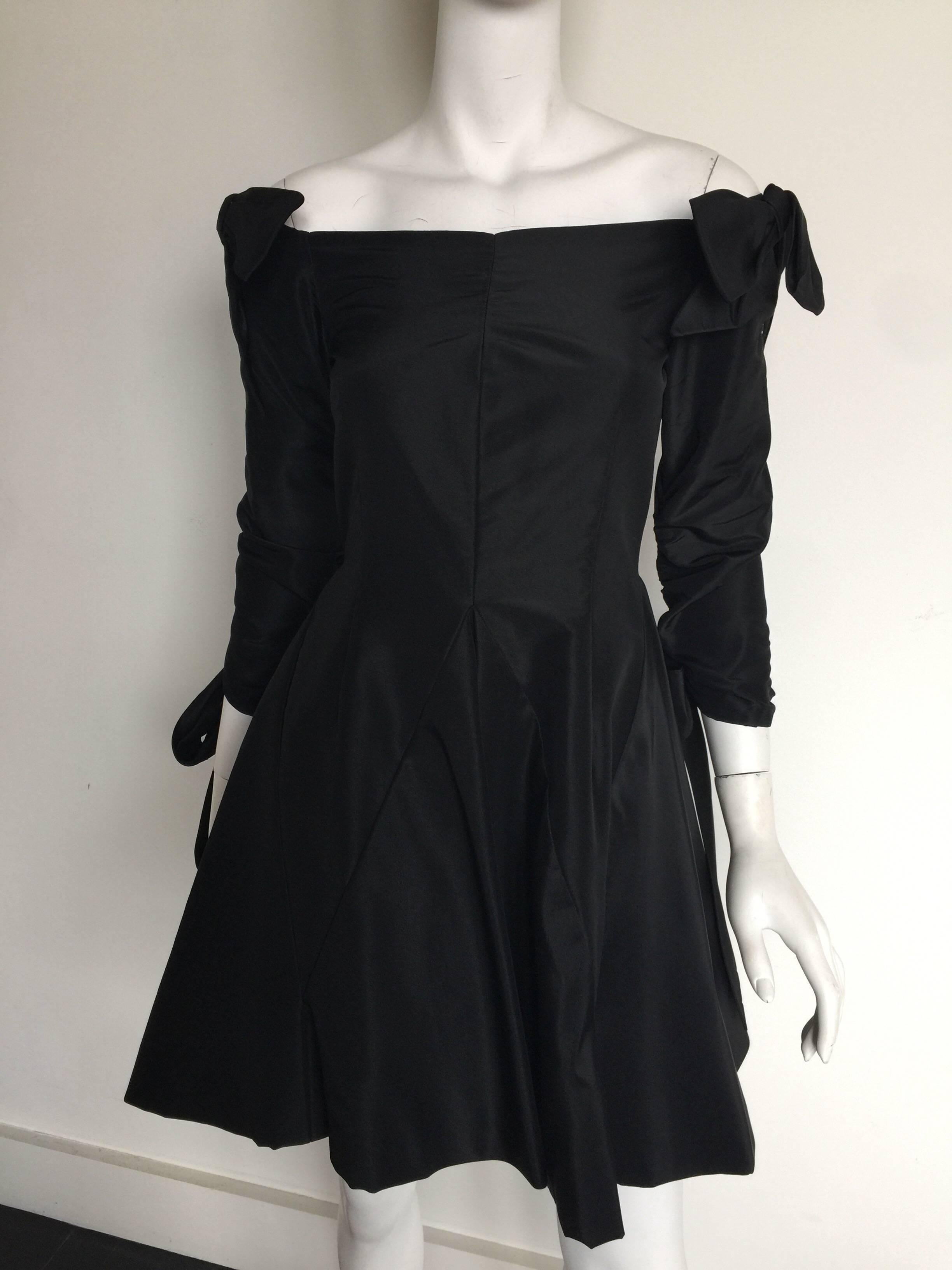 This iconic silk taffeta Bill Glass party dress is from the 1980s.  It has a tight waist and a short flare skirt with an off the shoulder bow detail.  