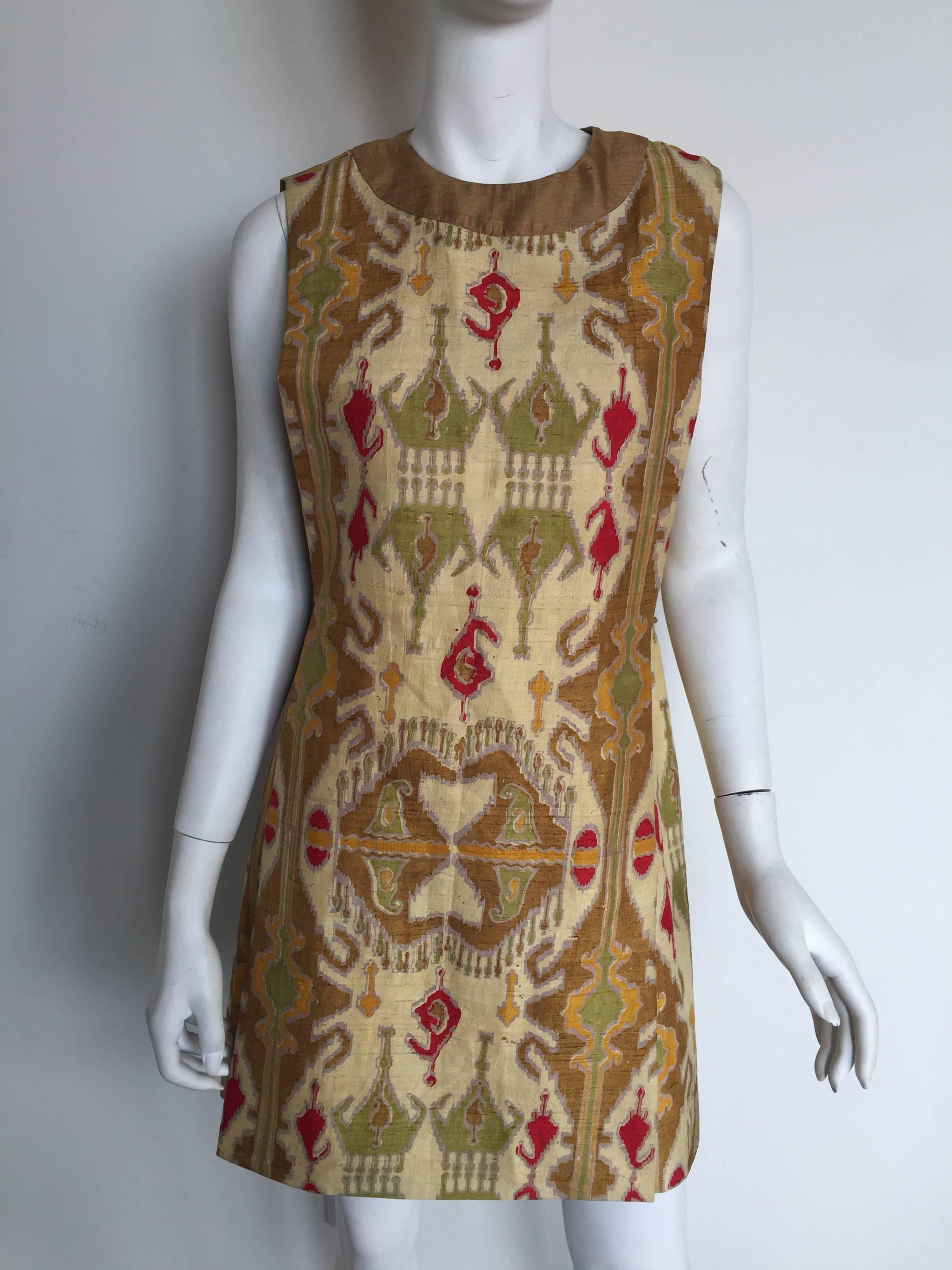 This Pierre Cardin ethnic print couture dress is from the 1960s.  It has a shift body shape with a apron silk over piece.  It has a hidden back zipper and a bow tie on one side.  It is 100% silk woven in India and labeled a size 10 but please check