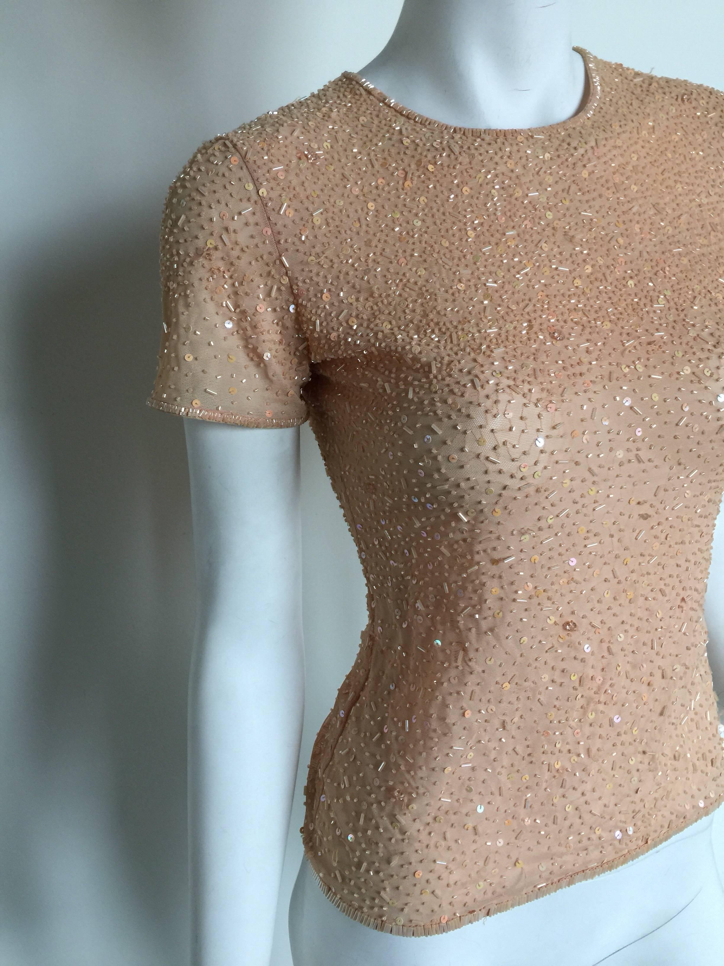Armani Nude Beaded Top fits a 0-4.  It has some missing beads on the front chest and is priced accordingly. It is very stretchy.