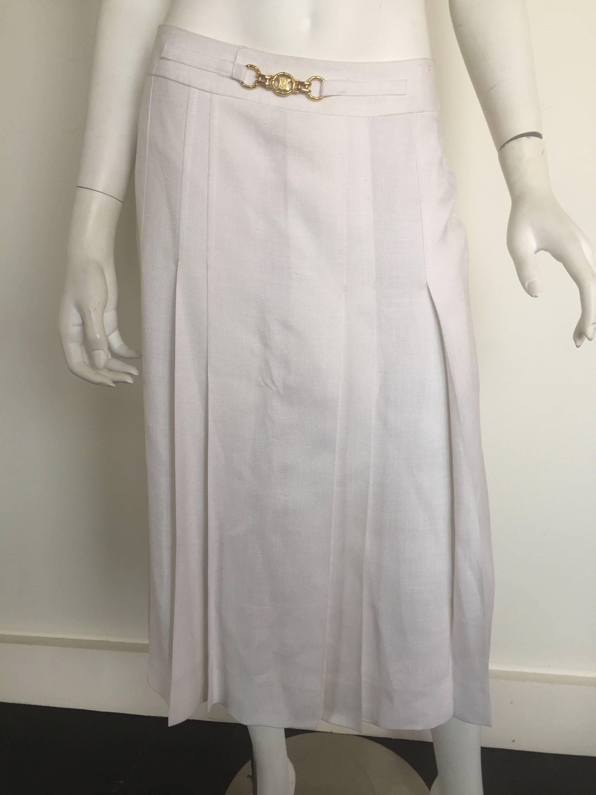 This 1970s Celine skirt has original tags and never worn.  It has two small rust dots most likely from hanger clips which could possible be removed and priced accordingly.  This skirt is linen with a Celine logo lining and gold Celine waist belt