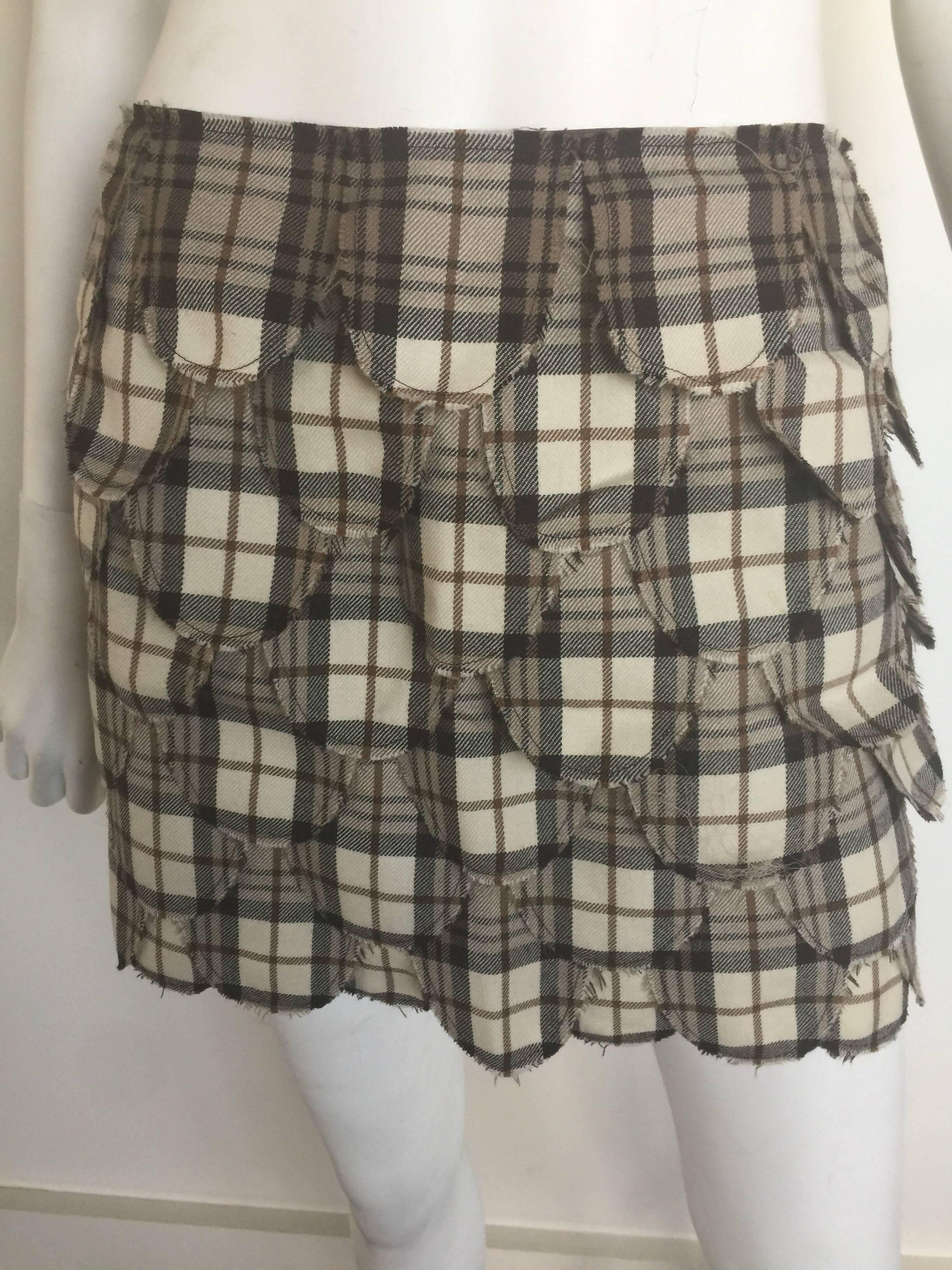 This is an adorable Cheap and Chic Moschino mini skirt.  It is a size 38 and pretty true to size.  It is a brown plaid and has scalloped pieces of fabric with a hidden side zipper. 