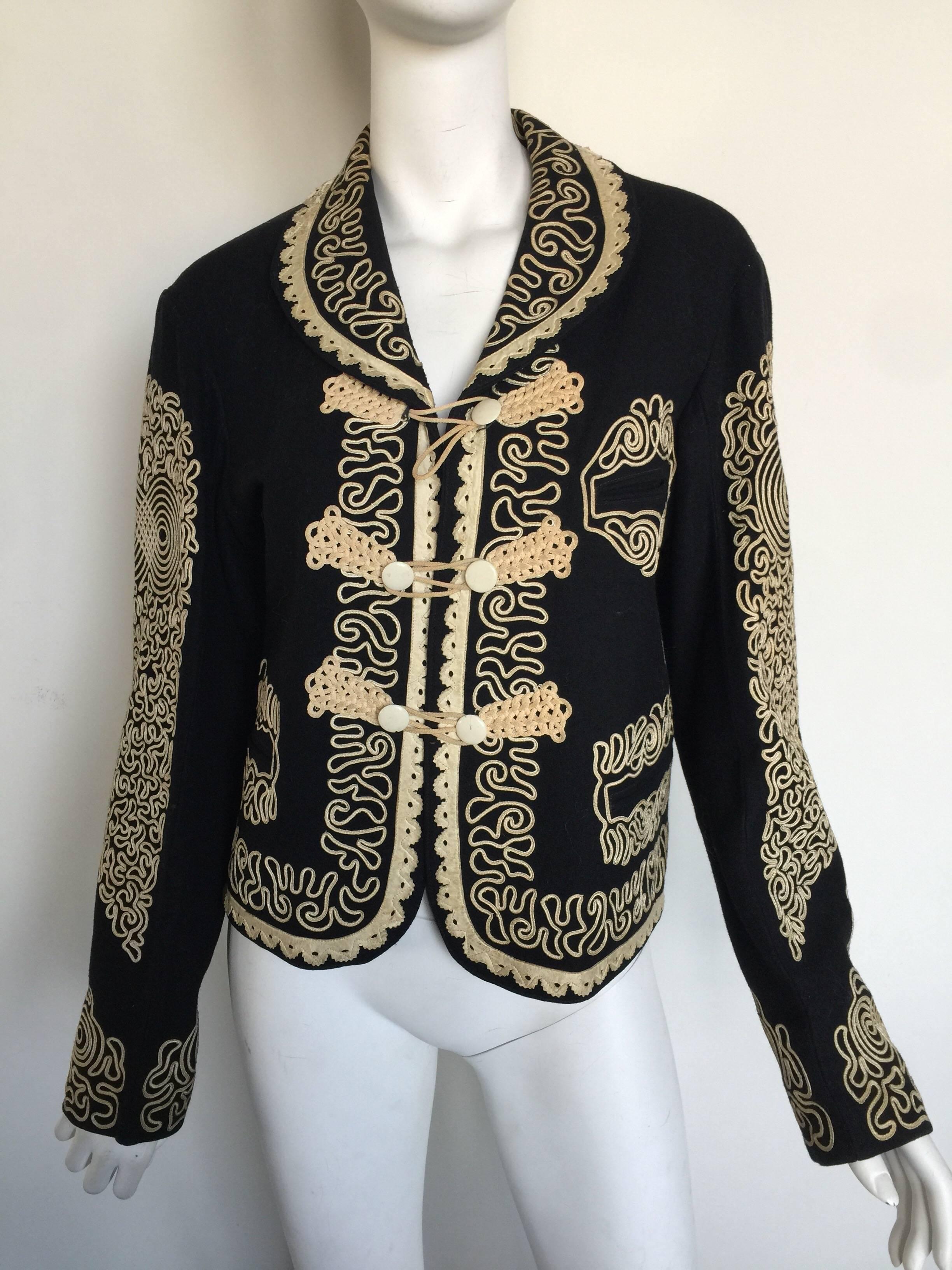 This wool coat has an intricate ribbon detailing and laser cut leather trim and eagle back.  It has slight discoloration on some areas of the ribbon but not very noticeable.  It fits a 0-4 but please check measurements.  It is from a NY atelier and