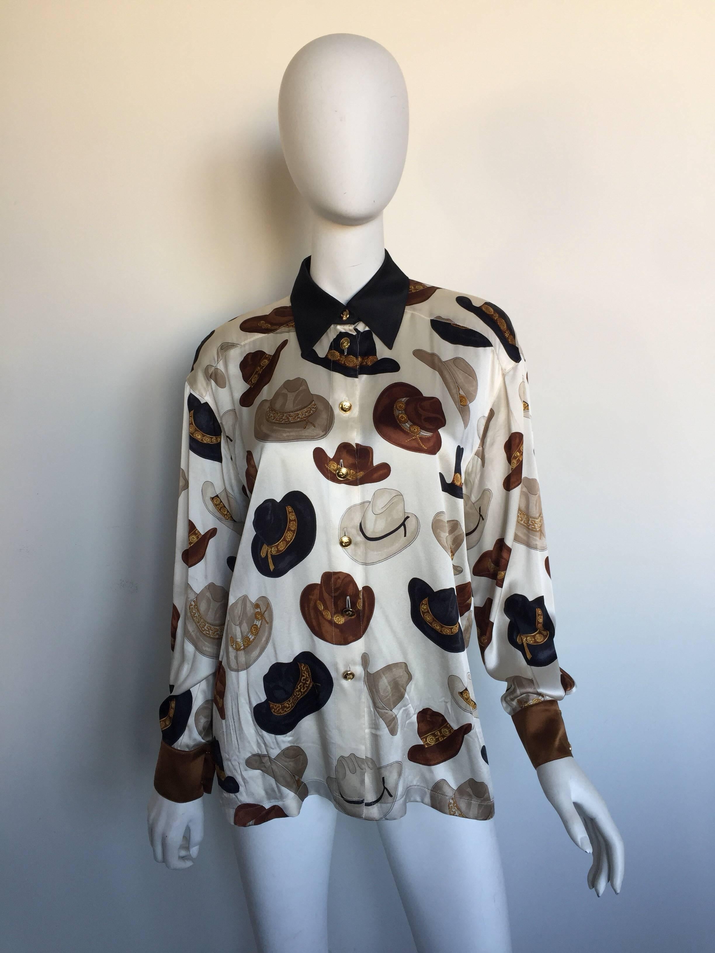 This Escada blouse is from the 1980s.  It is a silk blouse with a printed cowboy hat design and gold buttons down the front.  It is labelled a size 38 and meant to have a slightly oversized fit.  