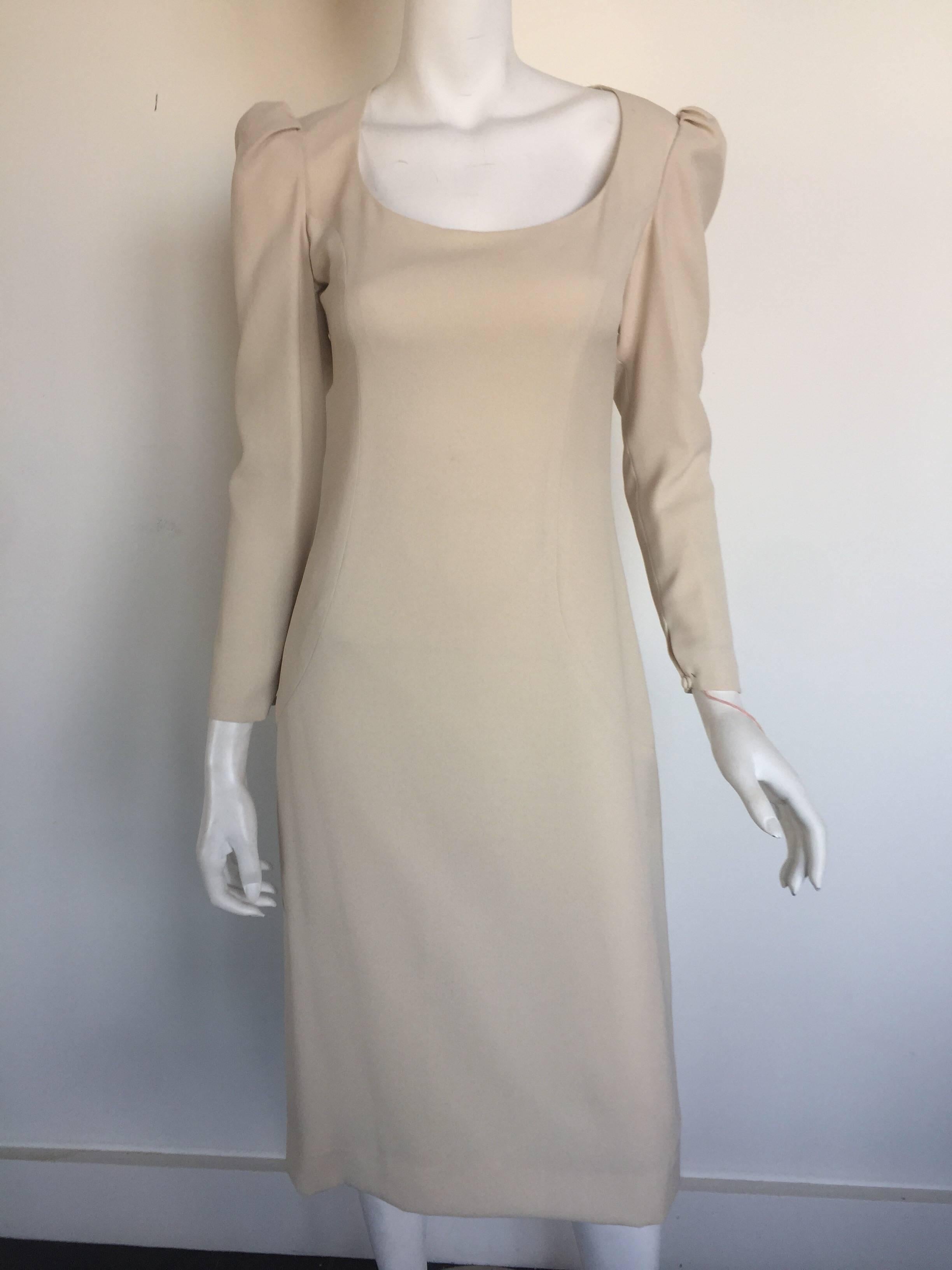 This Estevez is an off wife bone color.  It is a sheeth dress with feminine ruffled shoulders and long sleeves.  It has an open back with three both closures.  It is a size 4 but please check measurements.  