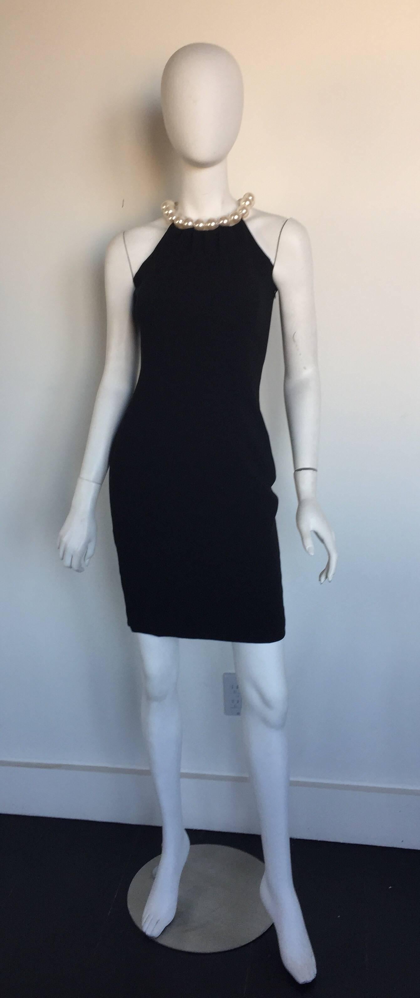 This Moschino little black dress has a A-Line fit and exaggerated pearl collar.  It is listed a size S and pretty true to size.
