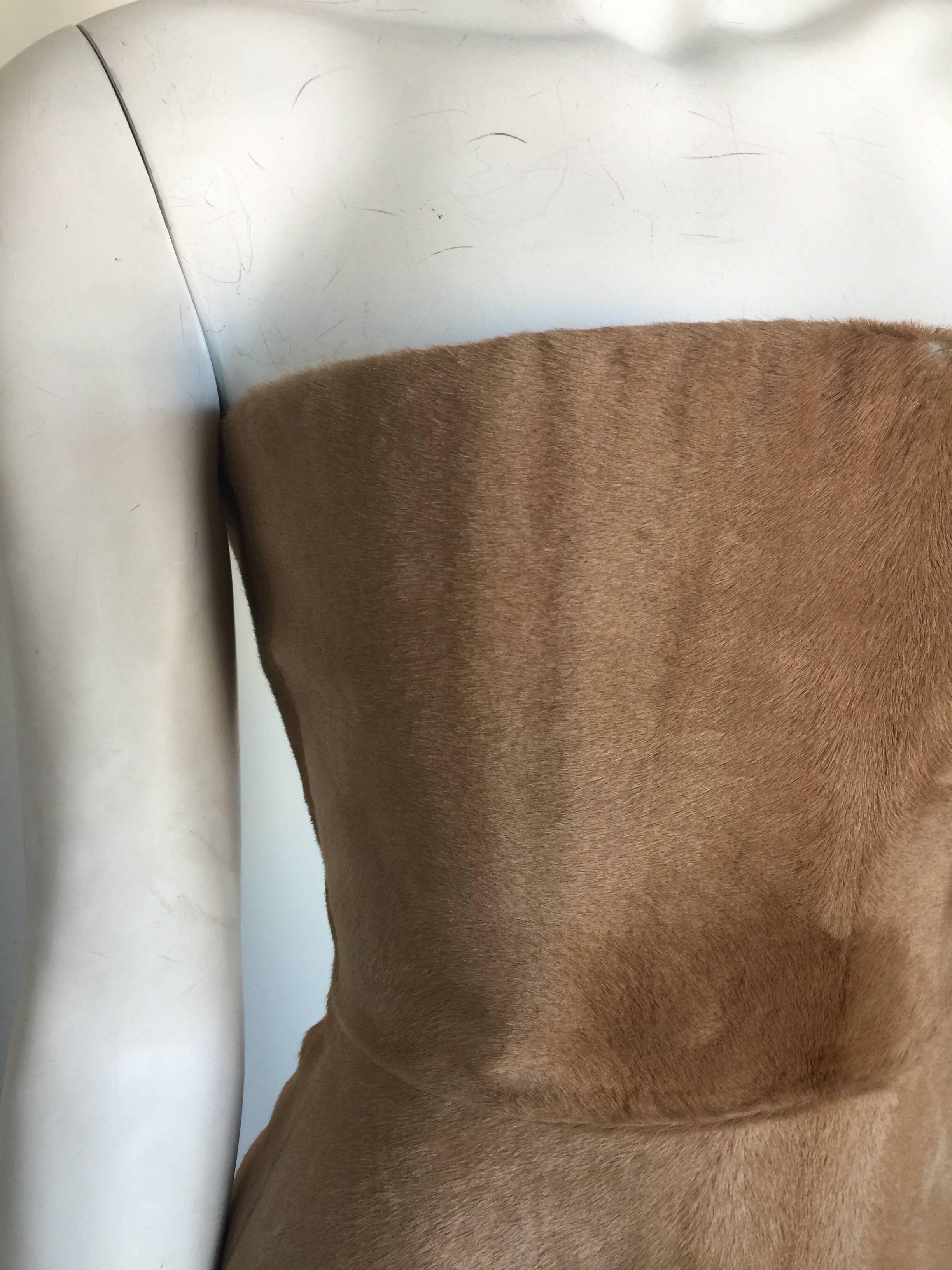 This Roberto Cavalli bustier is a tan pony hair. It has a little wear on the front edge as pictured.  It has a jewel print silk lining, ball zipper and peplum bottom. It is a size S but very small so please check measurements. 