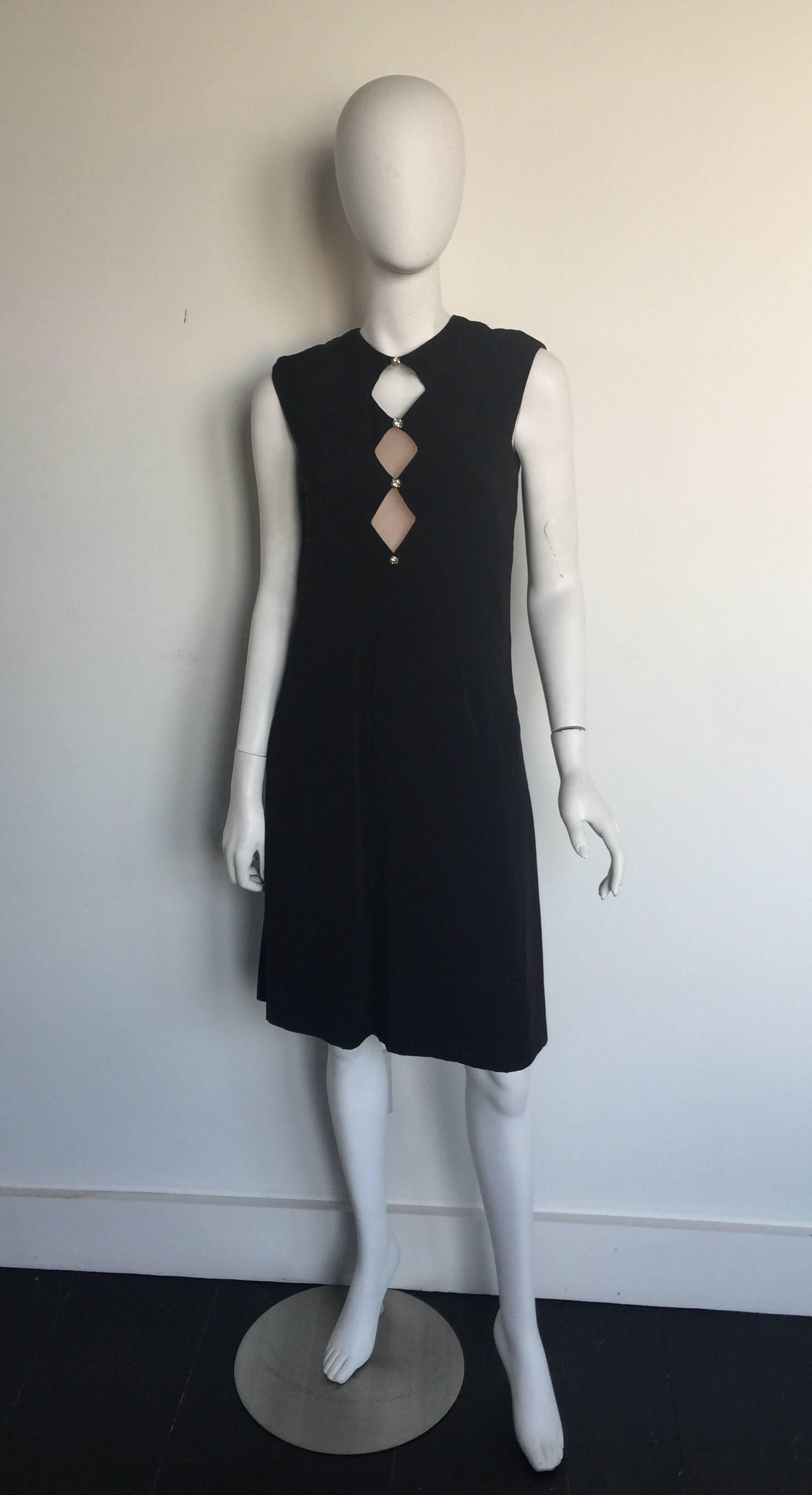 This black Estevez dress is from the 1970s.  It has a diamond shape cutout neckline with nude mesh in the second two diamonds.  It has crystal embellished buttons and the same open detailing on the back.  