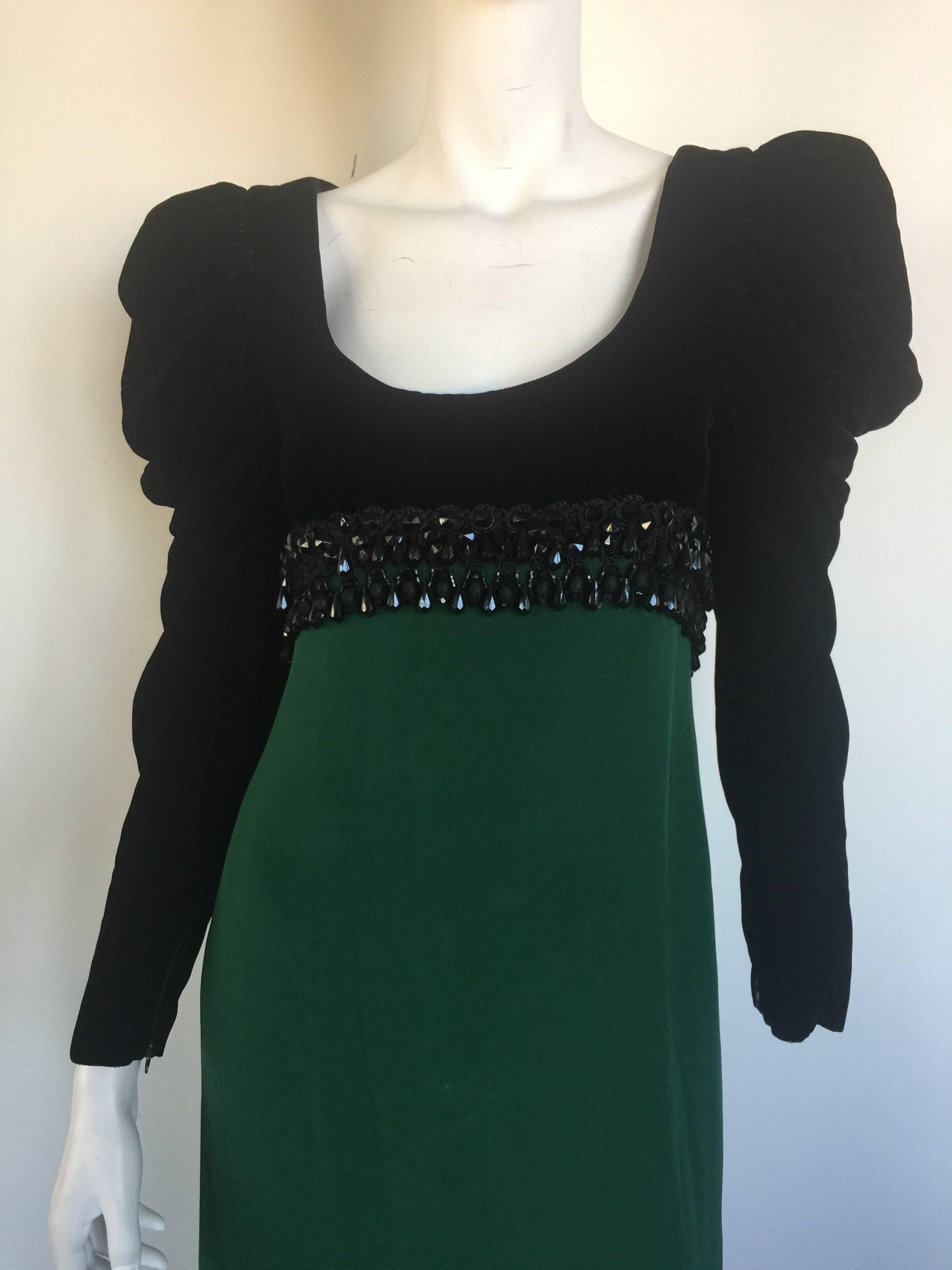 This empire waist black velvet and emerald silk gown is from the 1980s.  it has a beaded waistline and exaggerated shoulders and ruched sleeves. 