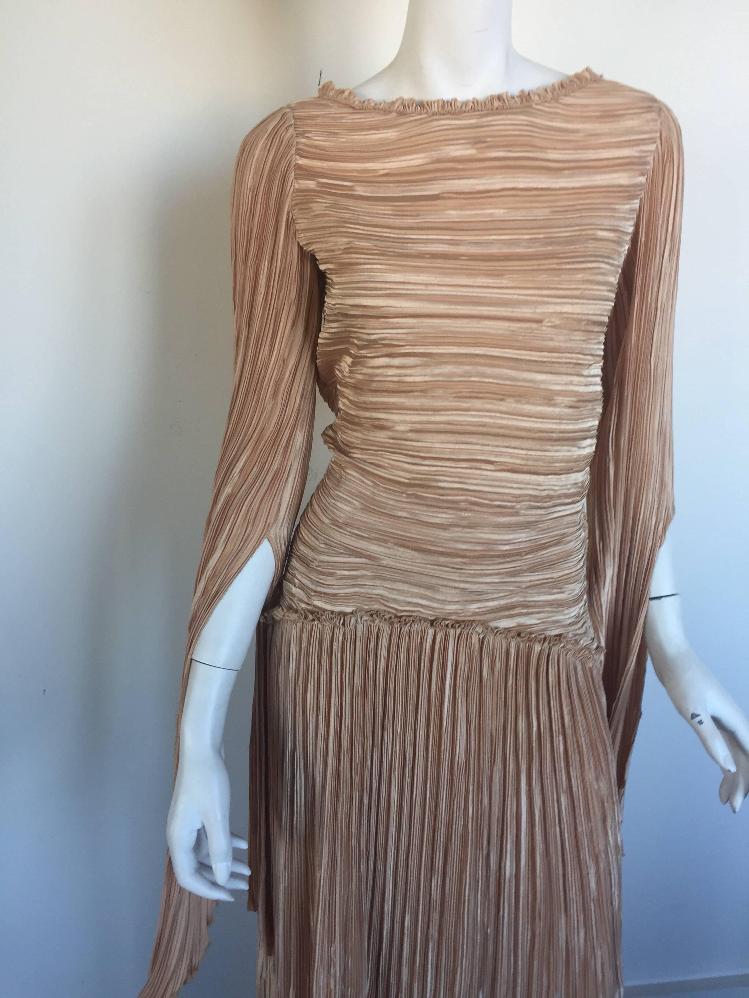 Thud nude Mary McFadden has a drop waist and long slit sleeves and a boat neck.  It is in fairly good condition with a few snags to fabric.  it has a double side zipper and is missing a size label but fits a small/medium.