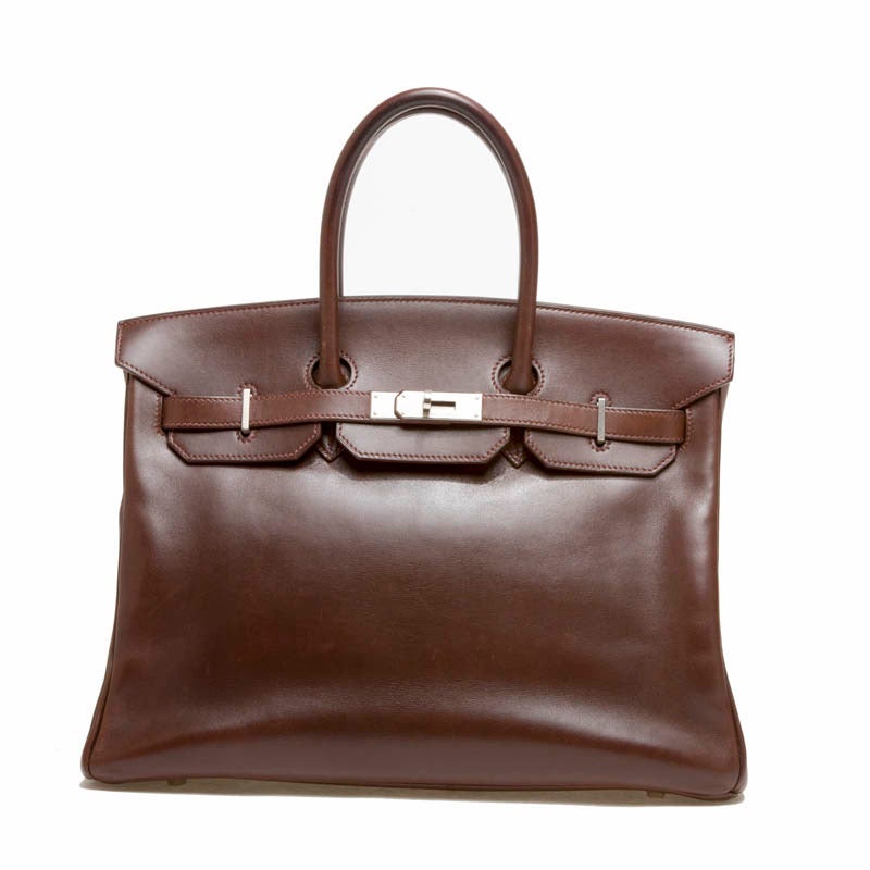 This elegant Hermes Birkin Box Calf Palladium Hardware in size 35 is the most sought-out bag to date. Accented with polished silver hardware, this Birkin exudes smooth rich brown leather. Subtle brown leather stitching is seen throughout the bag
