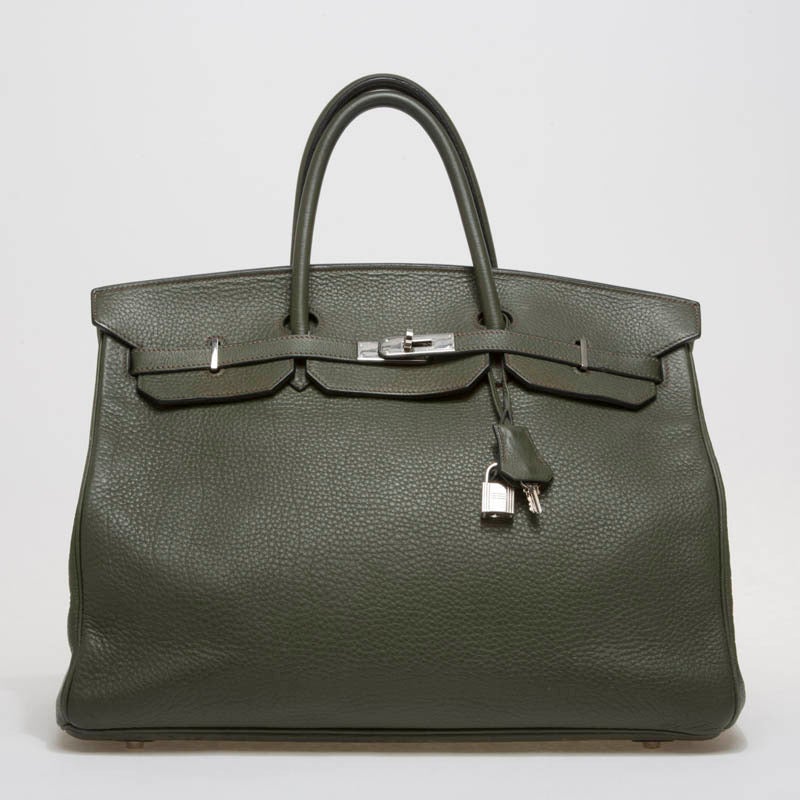 This is an authentic Hermes Birkin in size 40 in luxurious Vert Olive. This iconic piece is made in scratch-resistant clemence leather and accented with stunning palladium hardware. The bag features dual rolled leather handles, frontal flap, and
