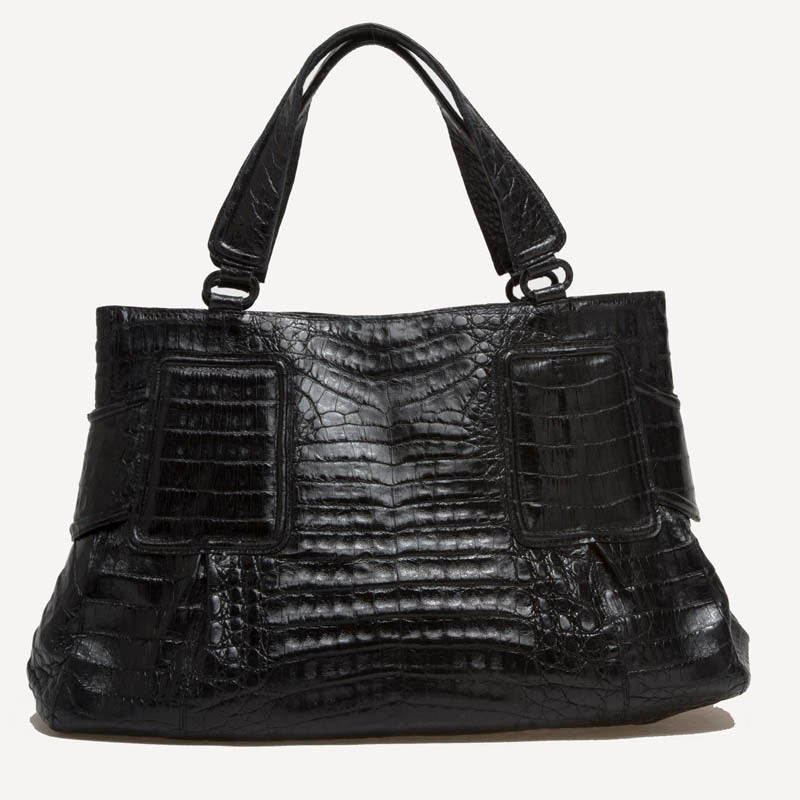 This authentic Nancy Gonzalez Tote Crocodile in size Medium is crafted with sleek genuine crocodile leather in black. This bag is a perfect polished look for work yet luxurious and exotic for an evening out. The interior features a side zip pocket