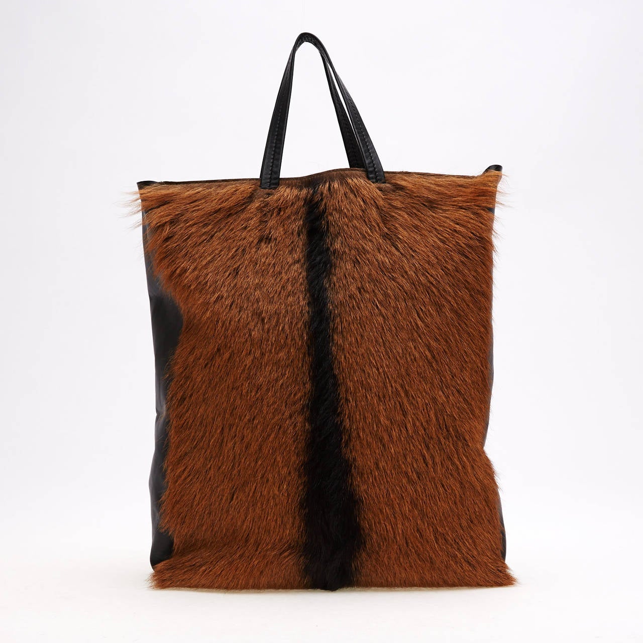 This stunning, rich Celine Cabas Fur Vertical Tote is sure to turn heads. This bag represents class and opulence. The rich soft brown and chocolate fur is paralleled with soft calfskin leather. The bag also features two leather handles and an