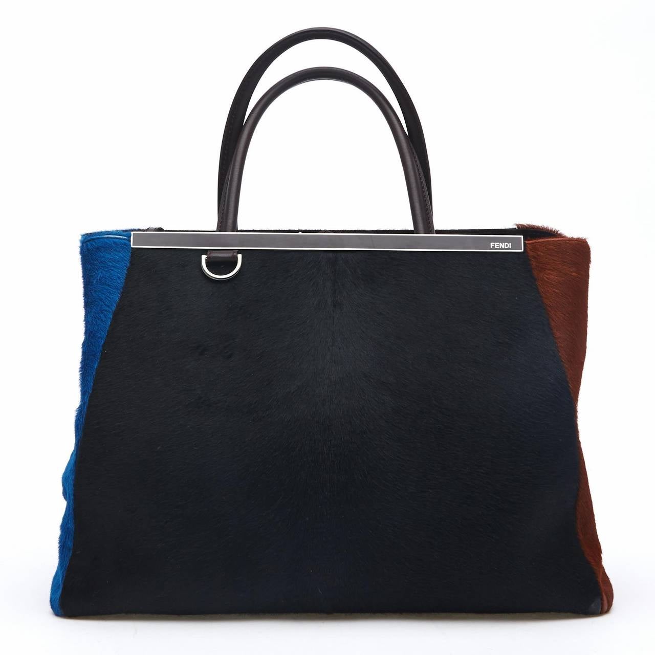 This tasteful Fendi Calf Hair 2Jours in Medium features a unique color block design of black, brown, and blue, and is perfect for the fall and winter. It is accented with a shining top bar that dons the Fendi brand name. It features a removable long