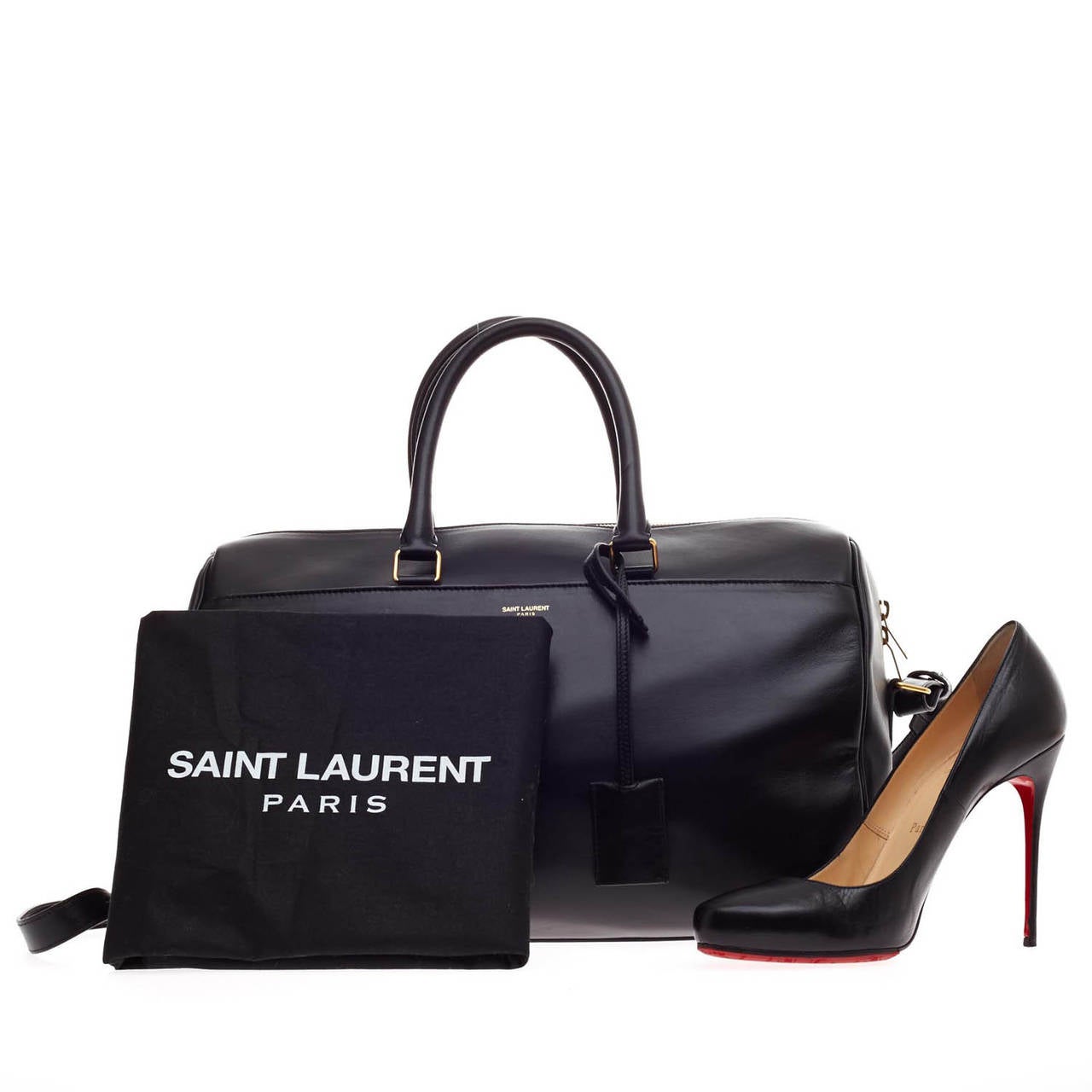 This authentic Saint Laurent Classic Duffle Leather 12 is a sleek, modern and an elegant duffle bag to travel in style with. Crafted with smooth black leather and gold tone hardware, this bag can be carried as a convenient hands free cross-body bag,