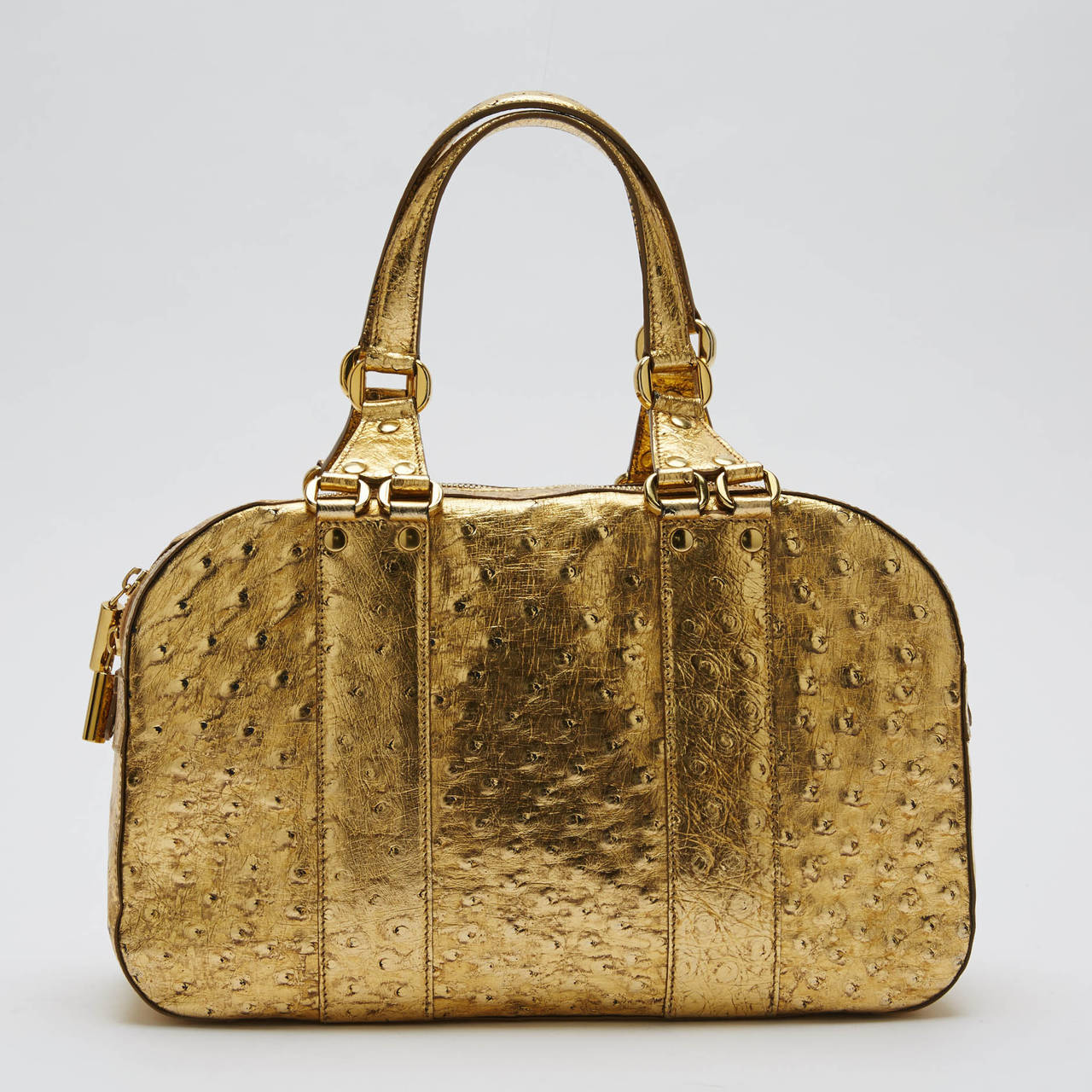 This beautiful, authentic gold ostrich duffle with gold hardware and suede lining is a very convenient handbag to buy as an everyday bag. This Donna Karan Duffle Ostrich Small offers plenty of space and it is easy to carry. **Note: These are