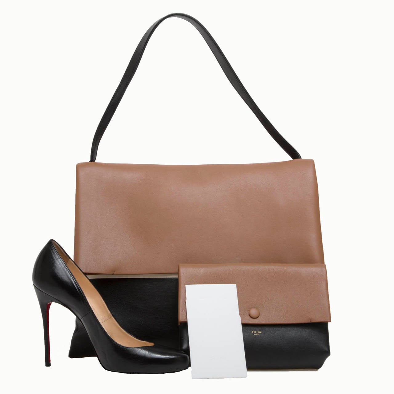 This beautiful Celine All Soft Tote is a desired handbag. It is constructed in tricolor calfskin leather in black, tan and white. This minimalist fold-over flap tote is light-weight and spacious and features a single leather strap. The matching