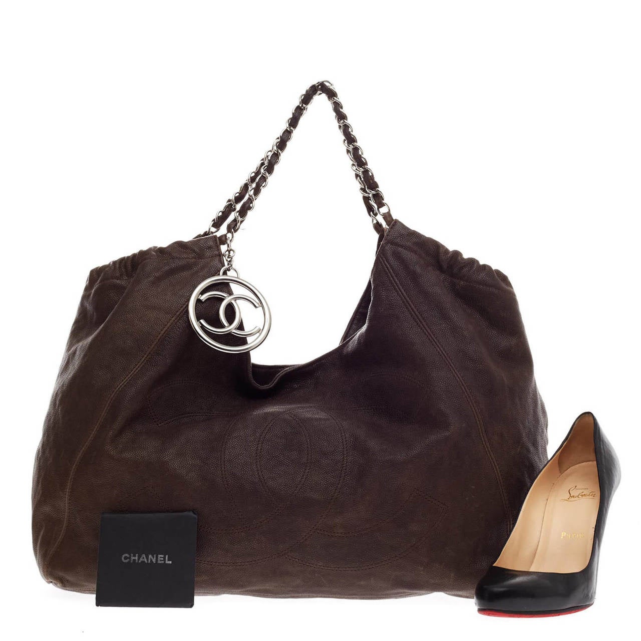 This authentic Chanel Coco Cabas Extra Large in earthy dark brown is finely crafted of luxurious distressed caviar leather. This roomy hobo features a large stitched Chanel CC frontal logo, ruching detail, leather woven silver chain handles, and a