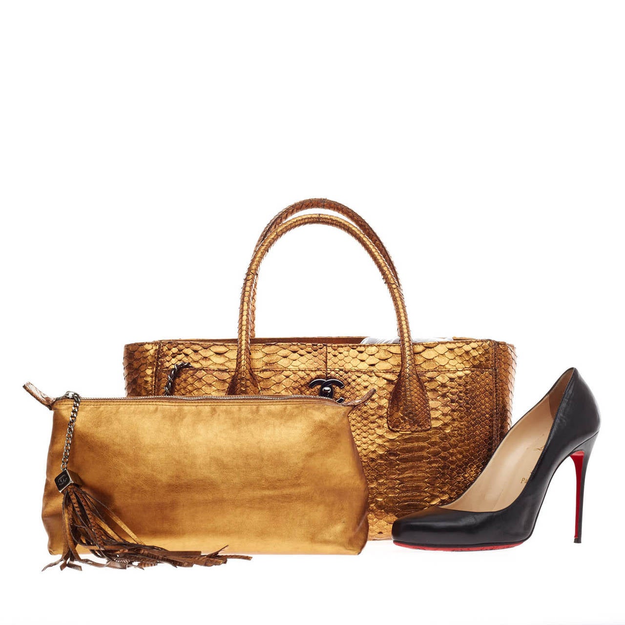 This authentic Chanel Cerf Tote Python in Medium is a luxurious and eye-catching statement piece. Crafted from sumptuous gold metallic python skin, this versatile tote features a matching gold removable interior pochette with tassel charm, long