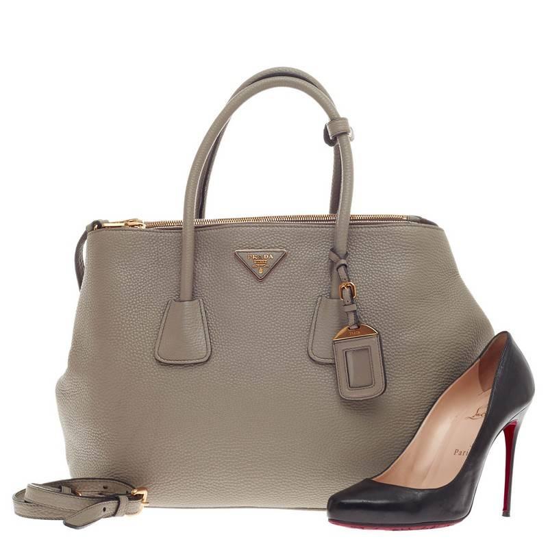 This authentic Prada Double Zip Convertible Tote Vitello Daino Large is simple yet luxurious perfect for everyday use. Crafted in argilla gray vitello daino leather, this chic-casual tote features a signature raised Prada logo at the center,