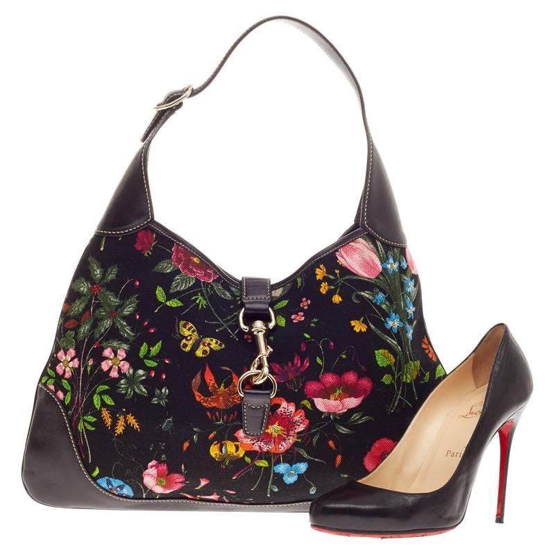 This authentic Gucci Jackie O Flora Canvas Medium is a must-have luxurious everyday hobo fit for the modern woman. Constructed from a beautiful multicolor floral canvas print with black leather trims, this iconic bag features an adjustable shoulder