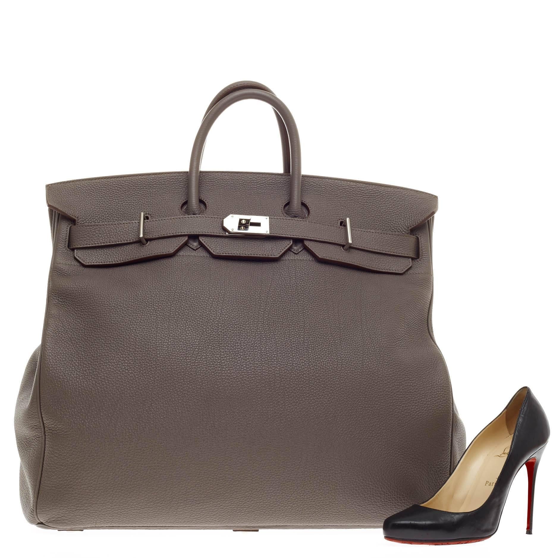 This authentic Hermes Birkin HAC Etain Togo with Palladium Hardware 50 exudes traditional Hermes luxury in coveted, larger-than-life proportions. Crafted in scratch-resistant etain gray togo leather, this unique, hard-to-find birkin HAC modeled