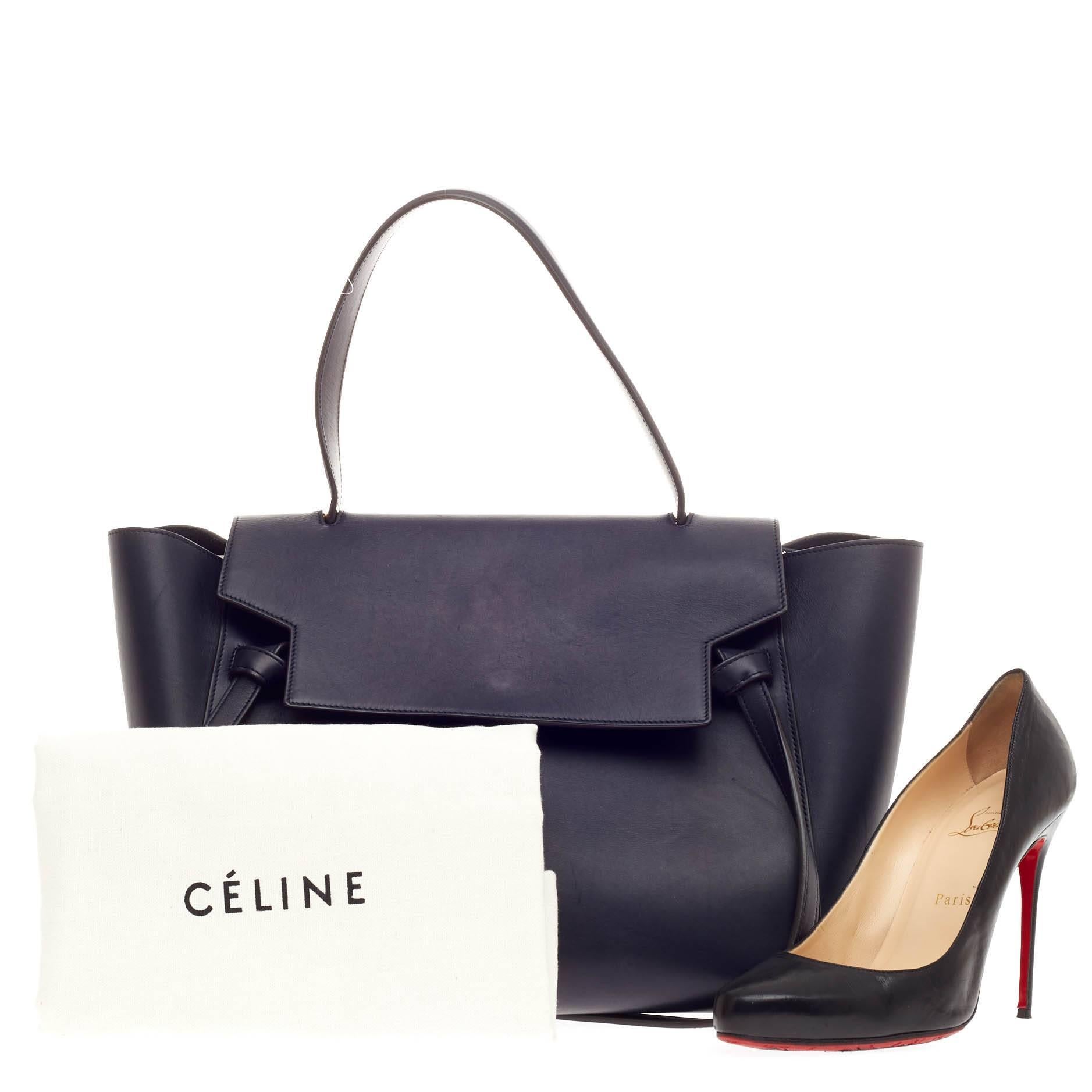 This authentic Celine Belt Bag Calfskin Medium is sure to make a statement. Crafted from beautiful navy blue calfskin leather, this bold and beautiful bag features expanded wings, looped single top handle, top flap slide closure, knotted ties,