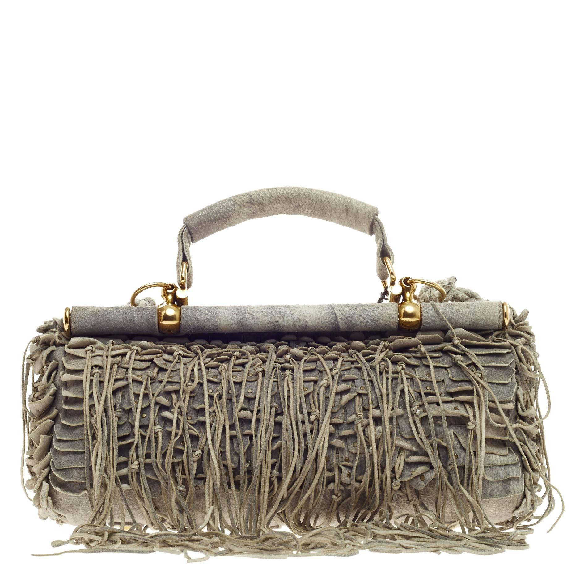 This authentic Roberto Cavalli Fringed Doctor Bag Distressed Suede debuting in 2011 mixes unique bohemian-glamour perfect for the most daring of fashionistas. Crafted in gray distressed suede, this eye-catching doctor bag features cascading knotted