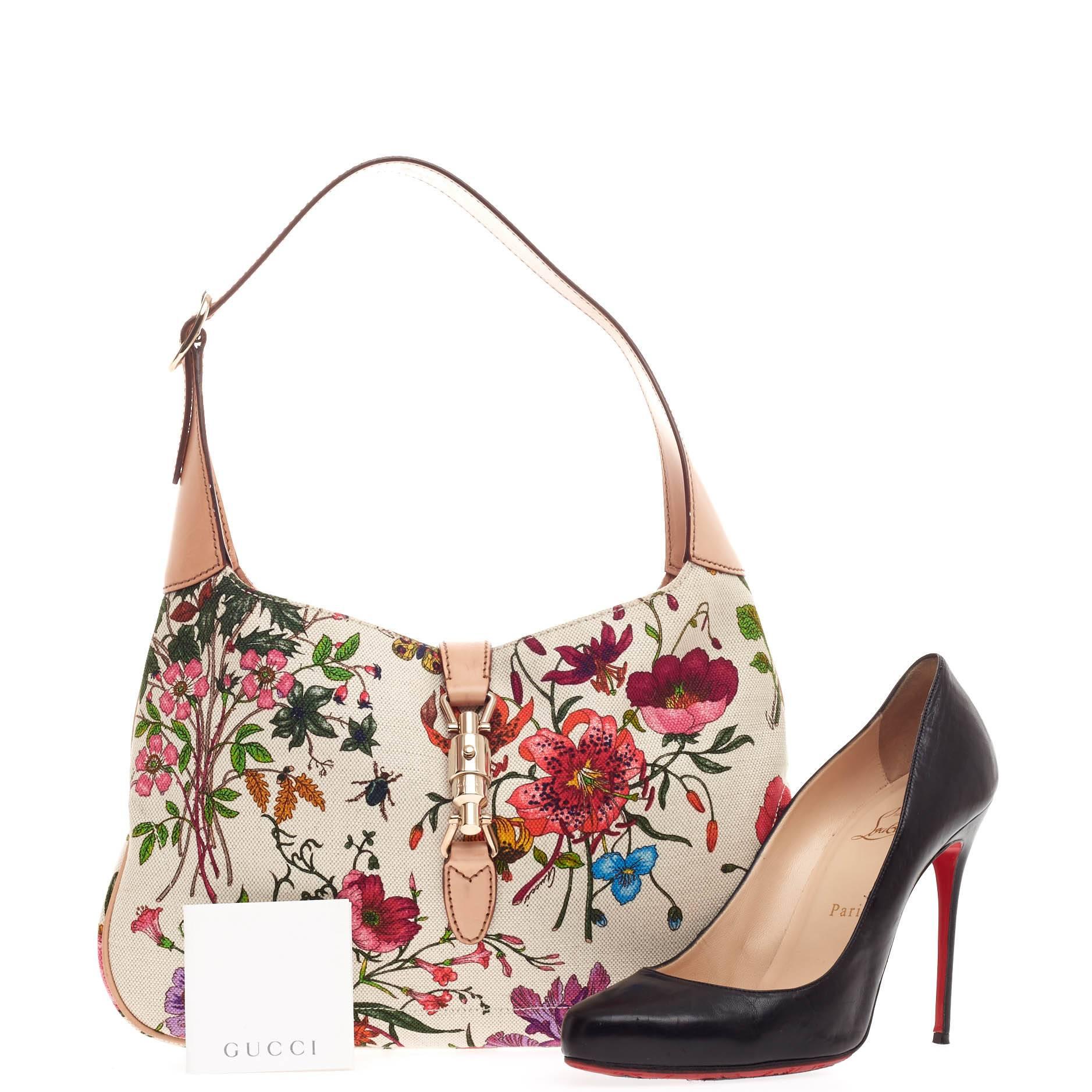 This authentic Gucci Jackie O Flora Canvas Small is a must-have everyday shoulder bag fit for the modern woman. Constructed from a beautiful multicolor floral canvas print with vachetta leather trims, this iconic bag features an adjustable shoulder