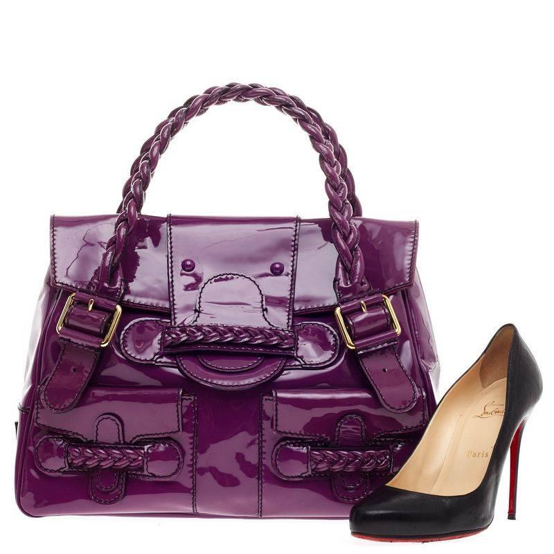 This authentic Valentino Histoire Satchel Patent is simple yet fun and chic in design perfect for daily outfits. Crafted in purple patent leather, this feminine tote features a braided leather loop dual handle, frontal flap, two front flap pockets