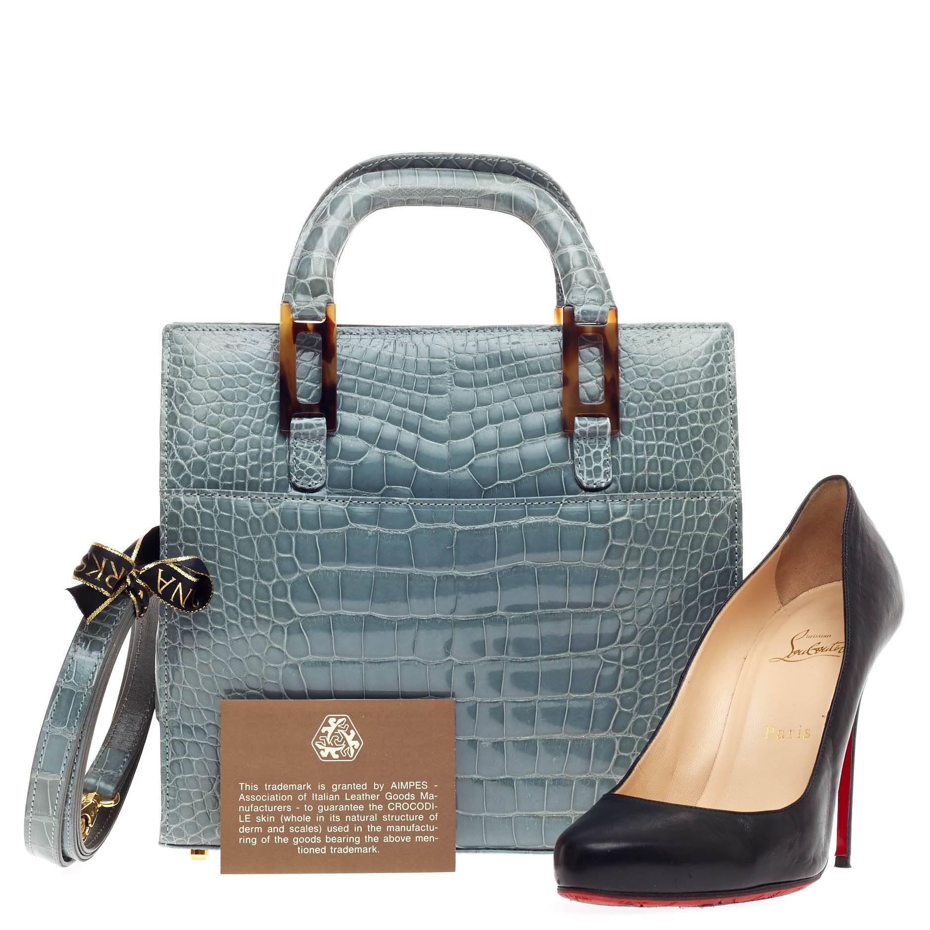 This authentic Lana Marks Convertible Zip Tote Crocodile Small is an exceptionally elegant masterpiece classic to Lana Marks. Hand-crafted in genuine powder blue-gray crocodile skin, this simple yet luxurious structured handle bag features