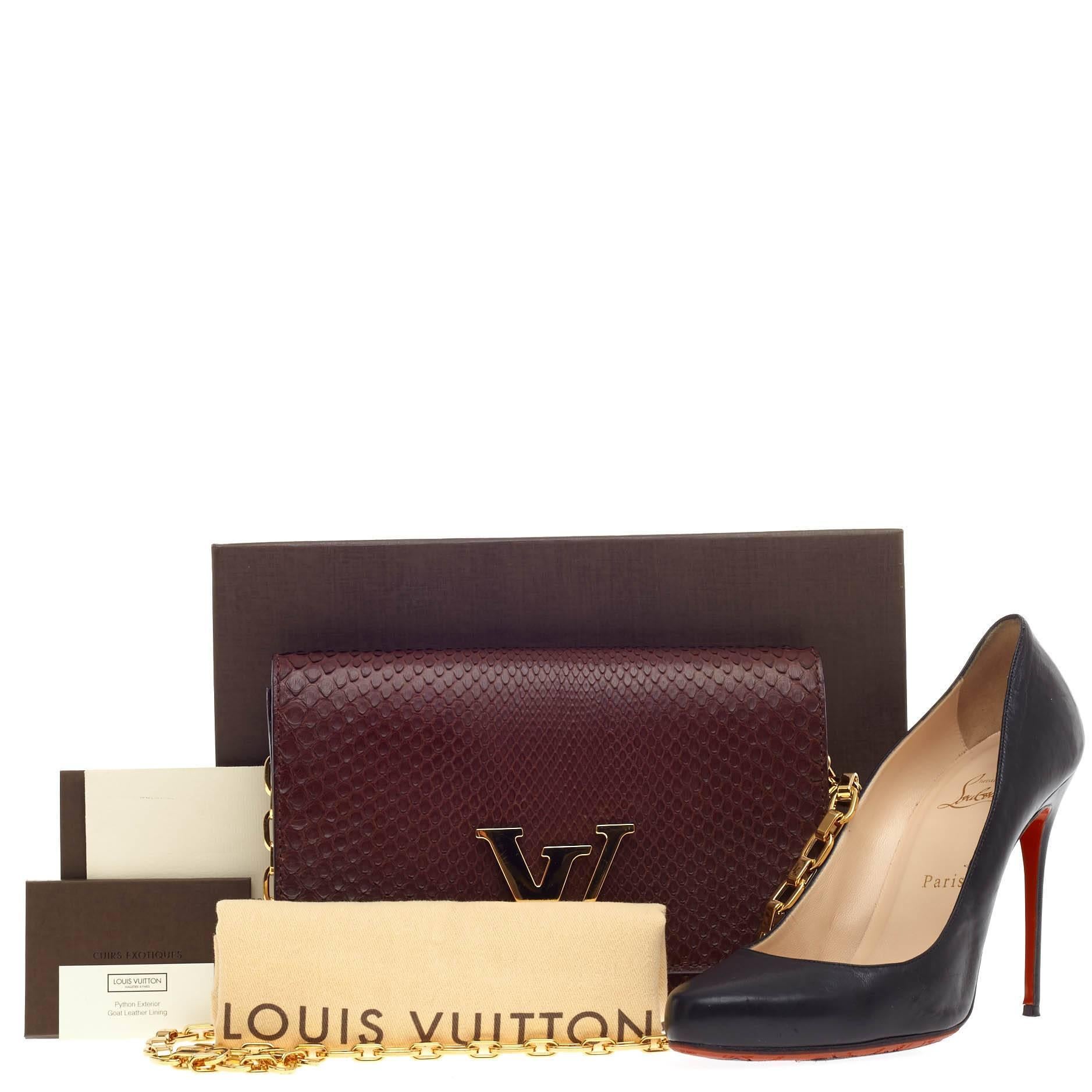 This authentic Louis Vuitton Chain Louise Clutch Python GM presented in the brand's Fall 2014 Collection is perfect for night outs. Crafted in quetsche dark purple genuine python skin with brown undertones, this modern yet feminine chain clutch