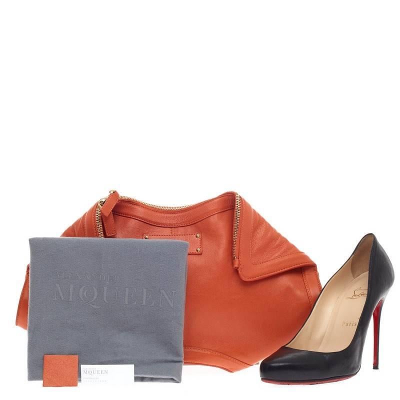 This authentic Alexander McQueen De Manta Clutch Leather Large crafted in orange leather is a stand-out clutch perfect for modern fashionistas. This oversized edgy, feminine clutch features magnetic flap top corners and leather logo embossed patch.