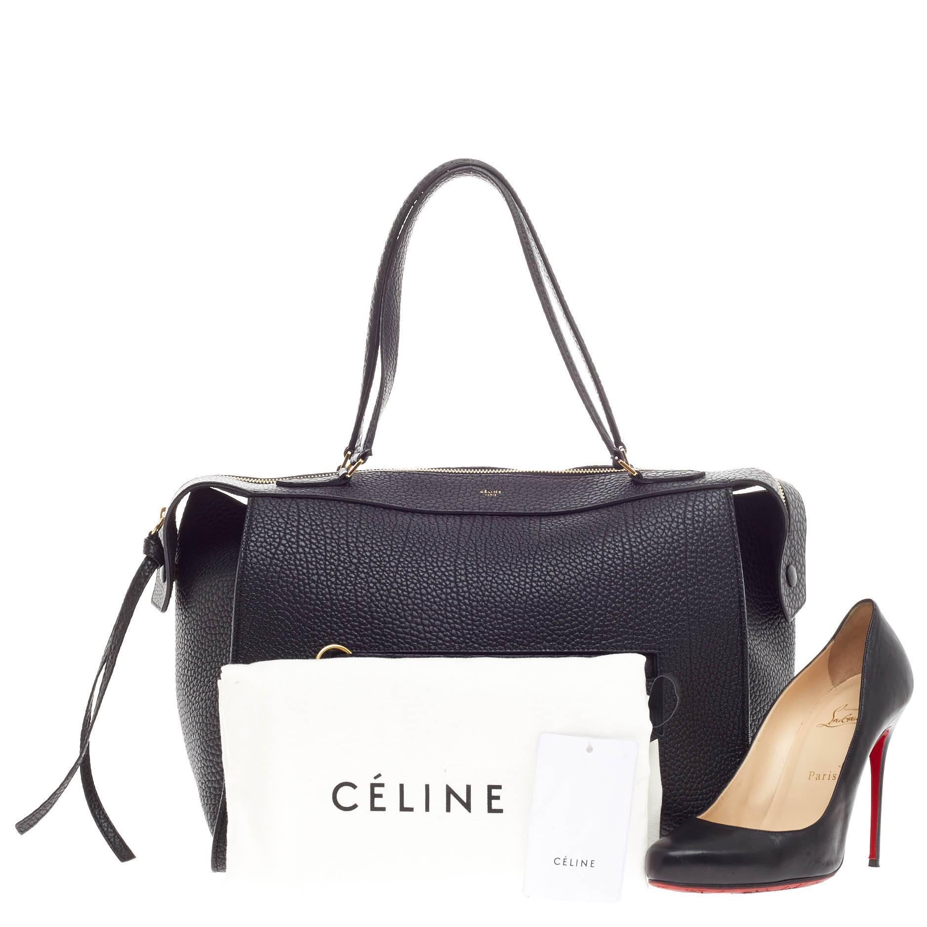 This authentic Celine Ring Bag Calfskin Medium presented in the brand's Spring 2015 Collection mixes clean sophistication with understated functionality. Designed in black bullhide calfskin leather, this subdued satchel features a soft-structured