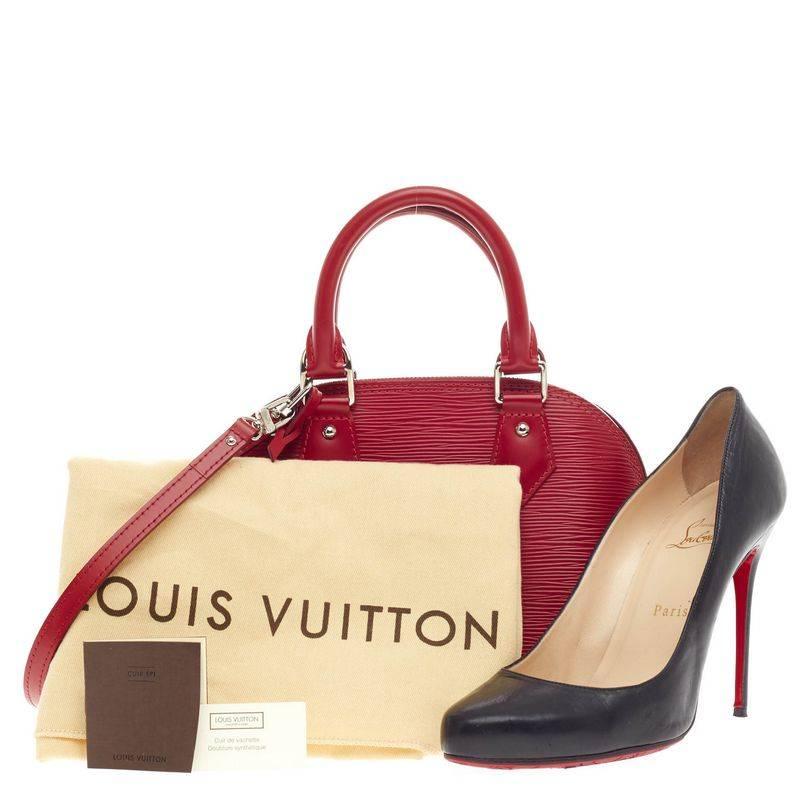 This authentic Louis Vuitton Alma Epi Leather BB in bold, rouge red is as elegant and classic as they come. Constructed with Louis Vuitton's signature sturdy epi leather, dome-like silhouette and sturdy base, this petite bag's structured design is