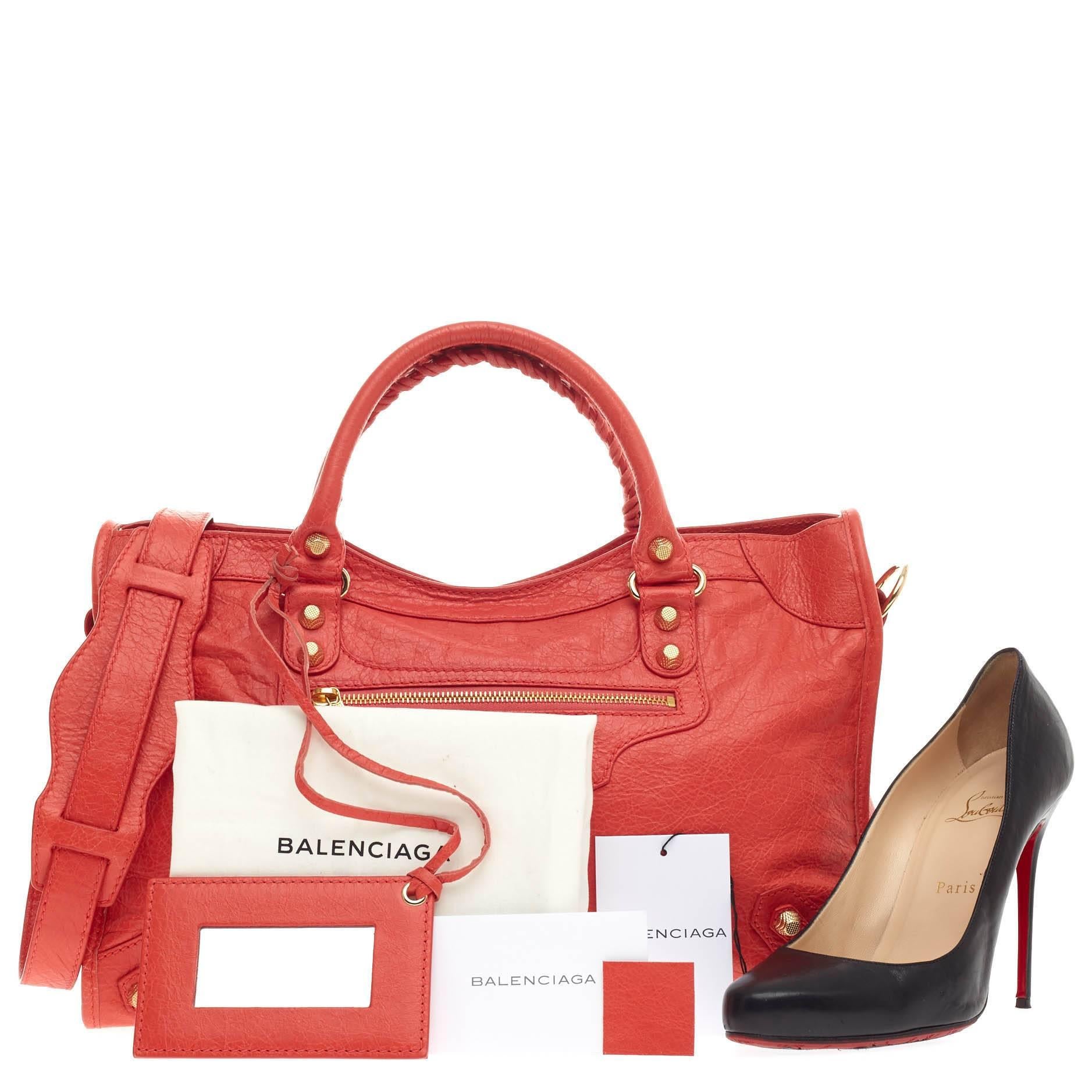 This authentic Balenciaga City Giant Studs Leather Medium is for the on-the-go fashionista. Constructed in beautiful rose corail distressed leather, this popular bag features braided woven handle straps, front zipper pocket, and iconic Balenciaga