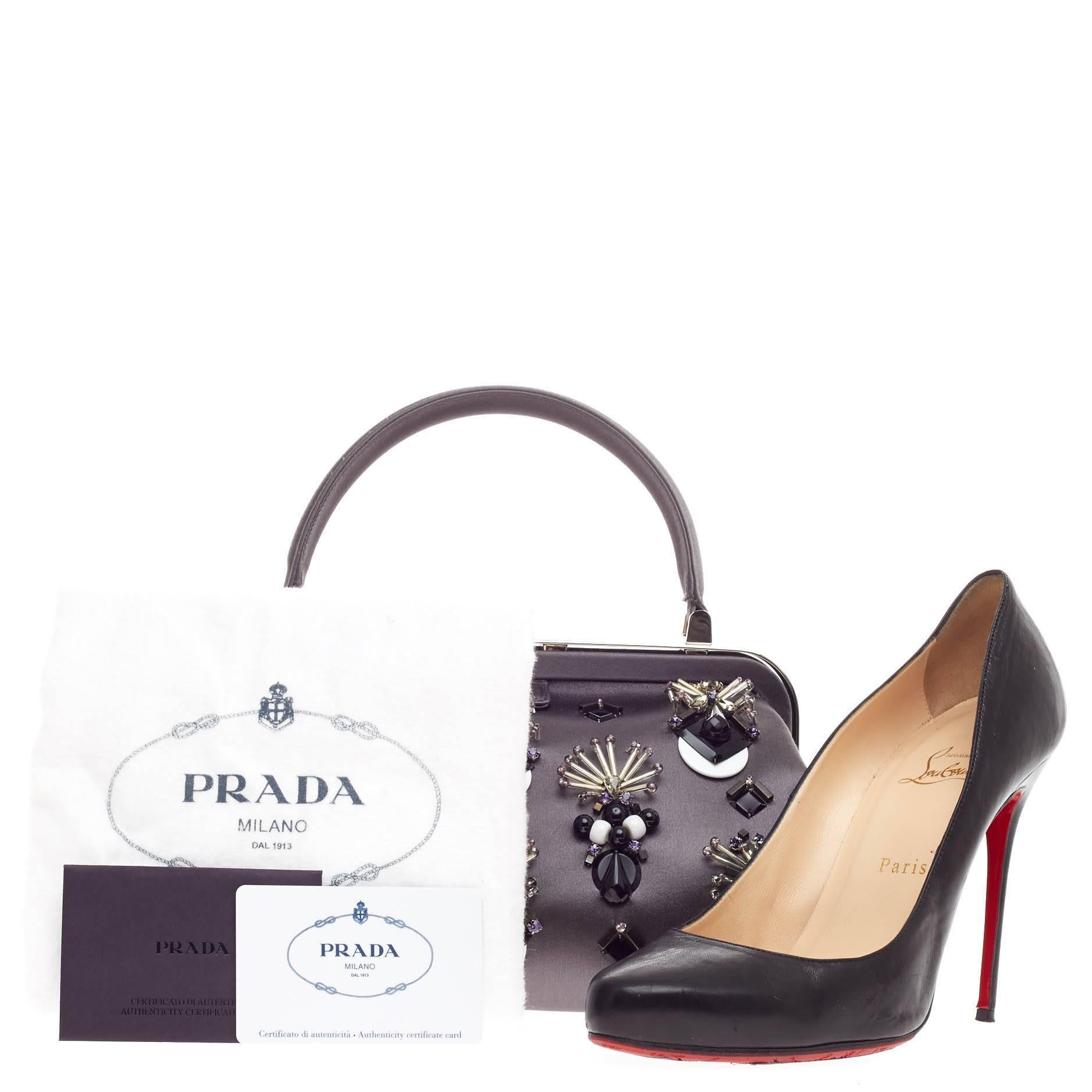 This authentic Prada Raso Ricamo Framed Doctor's Bag Jeweled Satin Medium presented in the brand's Fall 2012 Runway Collection is an elegant, formal piece made for the modern woman. Crafted in gray satin and embellished with decorative, intricate